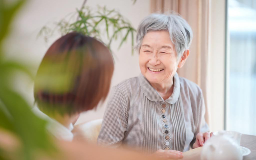 An elderly Japanese woman speaking with a younger person