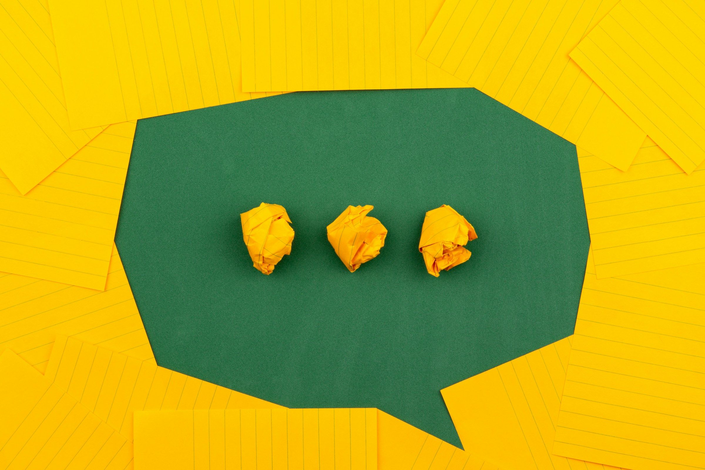A speech bubble made from green and yellow paper.