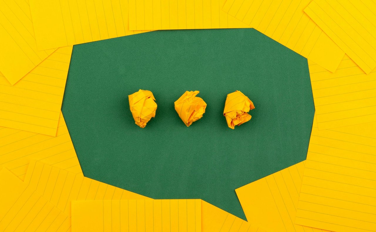 A speech bubble made from green and yellow paper.