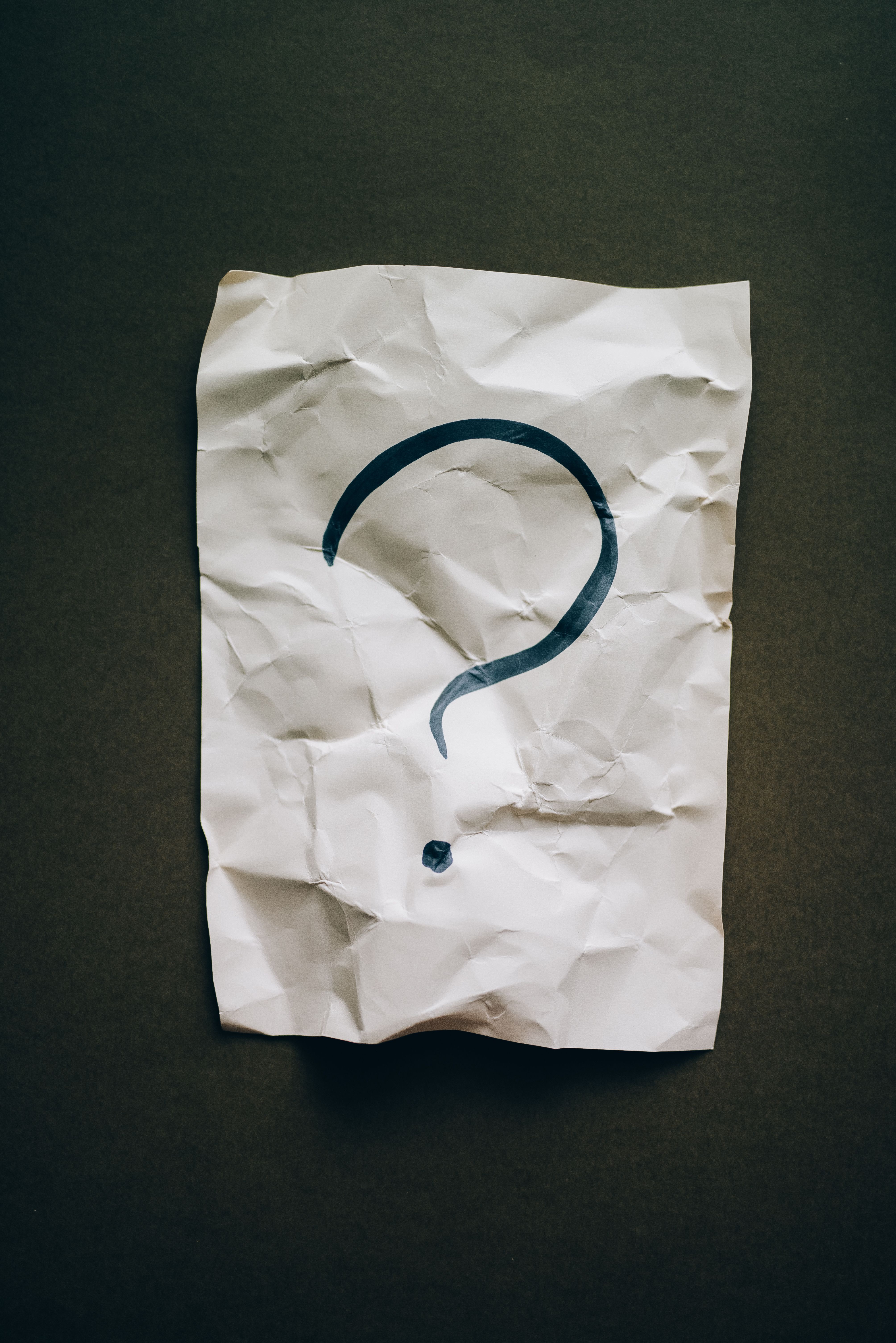 A question mark written on a piece of scrap paper.