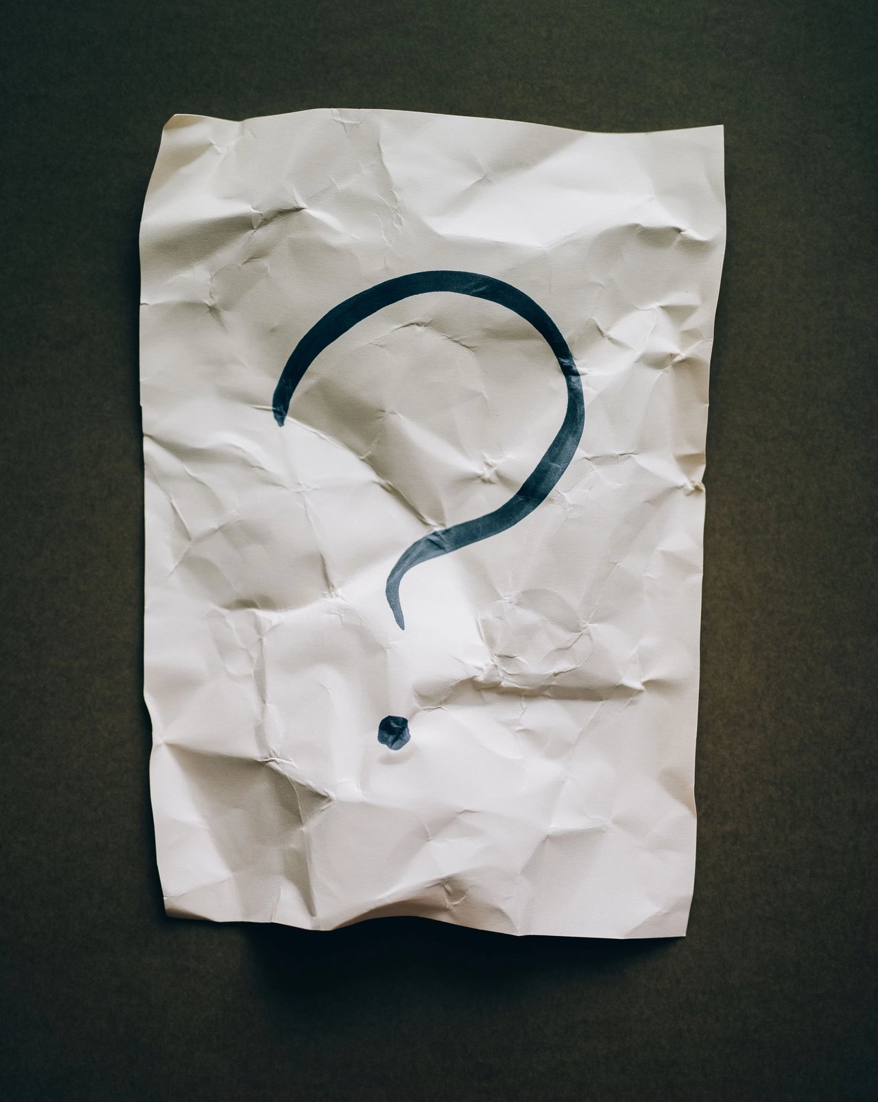 A question mark written on a piece of scrap paper.