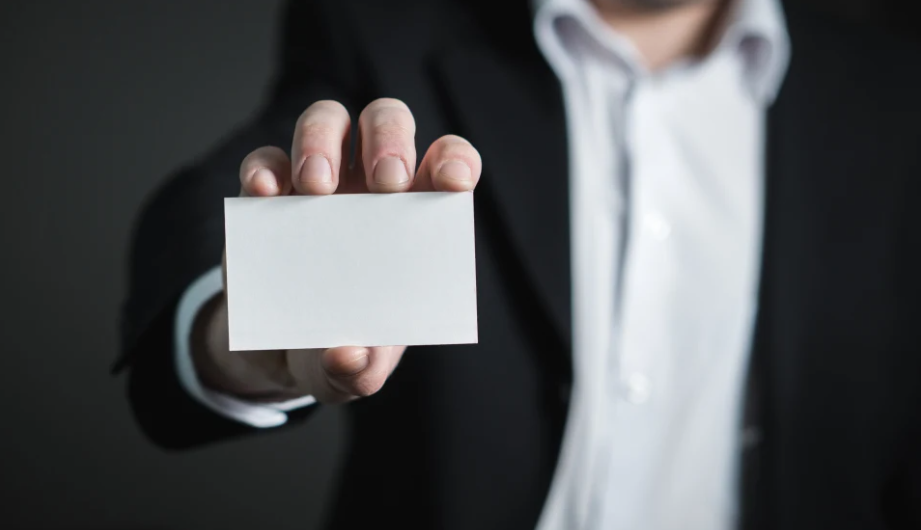 A man holding out a blank business card. 