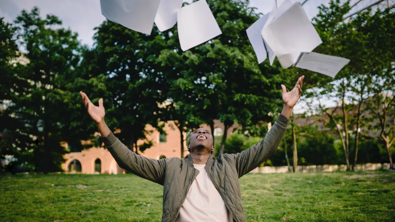A man throwing papers to the air. 