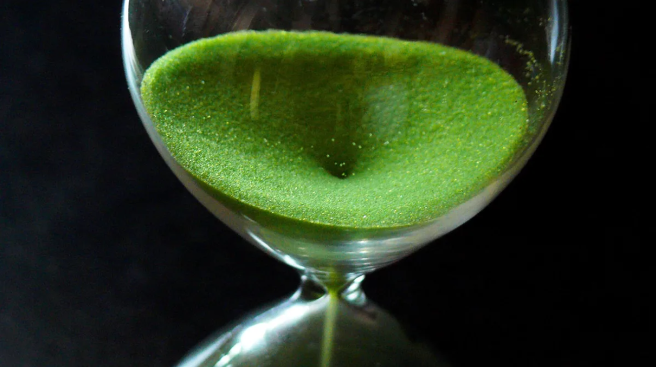 An hourglass with green sand.