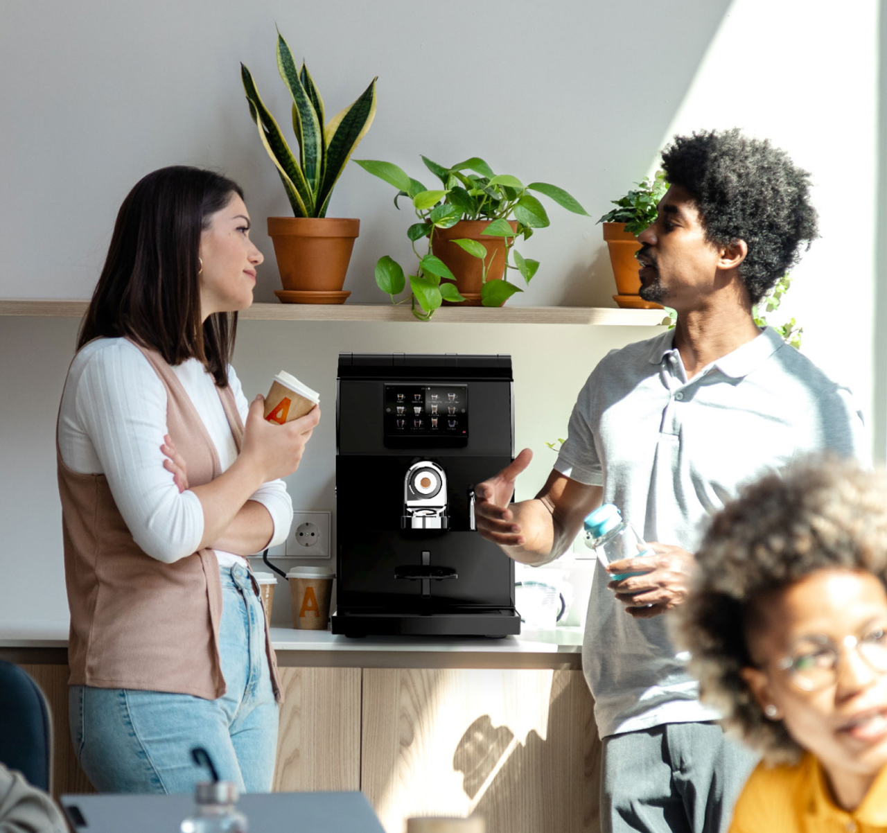 Deux collègues discutent autour de la machine à café