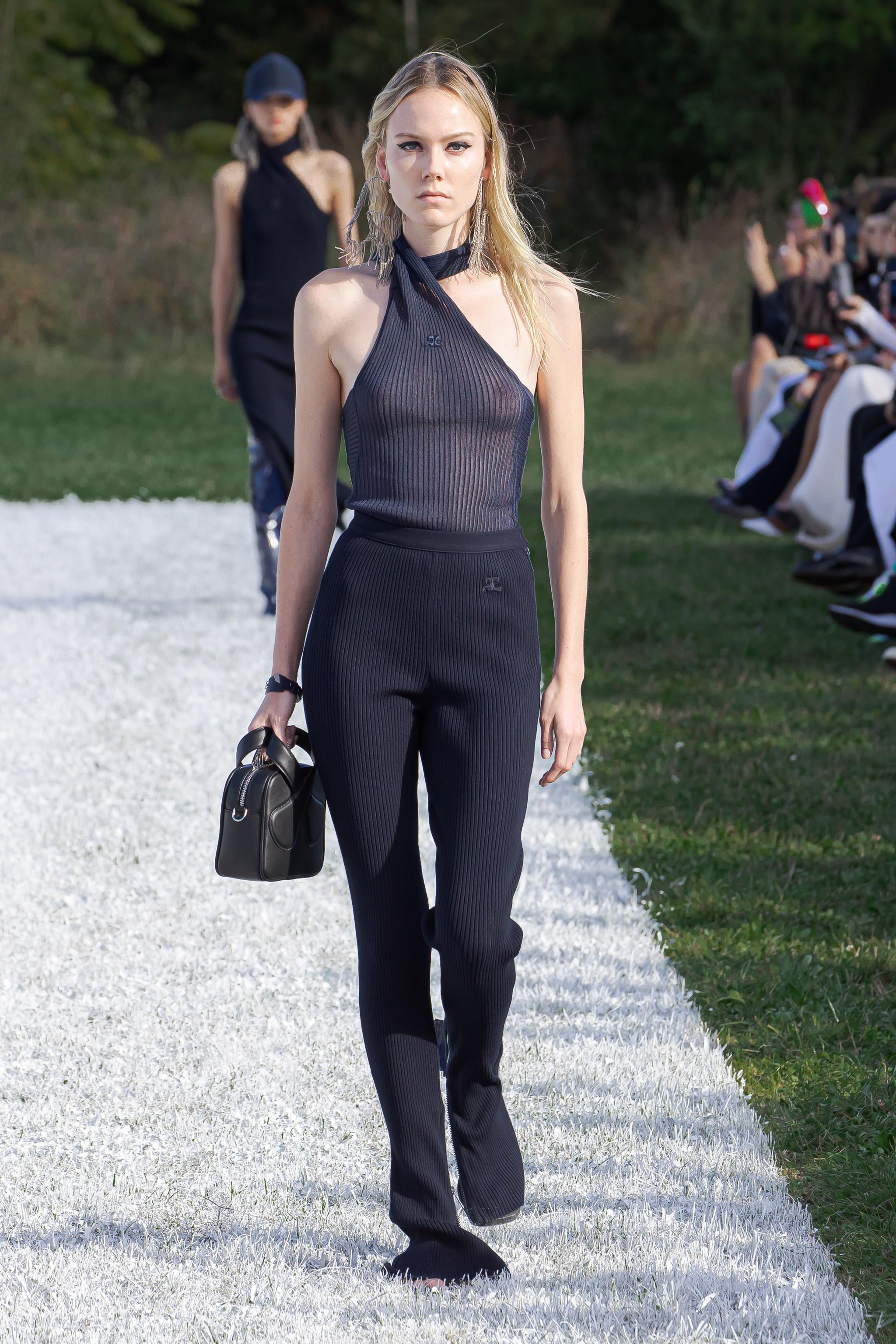 Elegant black ribbed sleeveless top and matching trousers on a model, Courrèges fashion showcase.