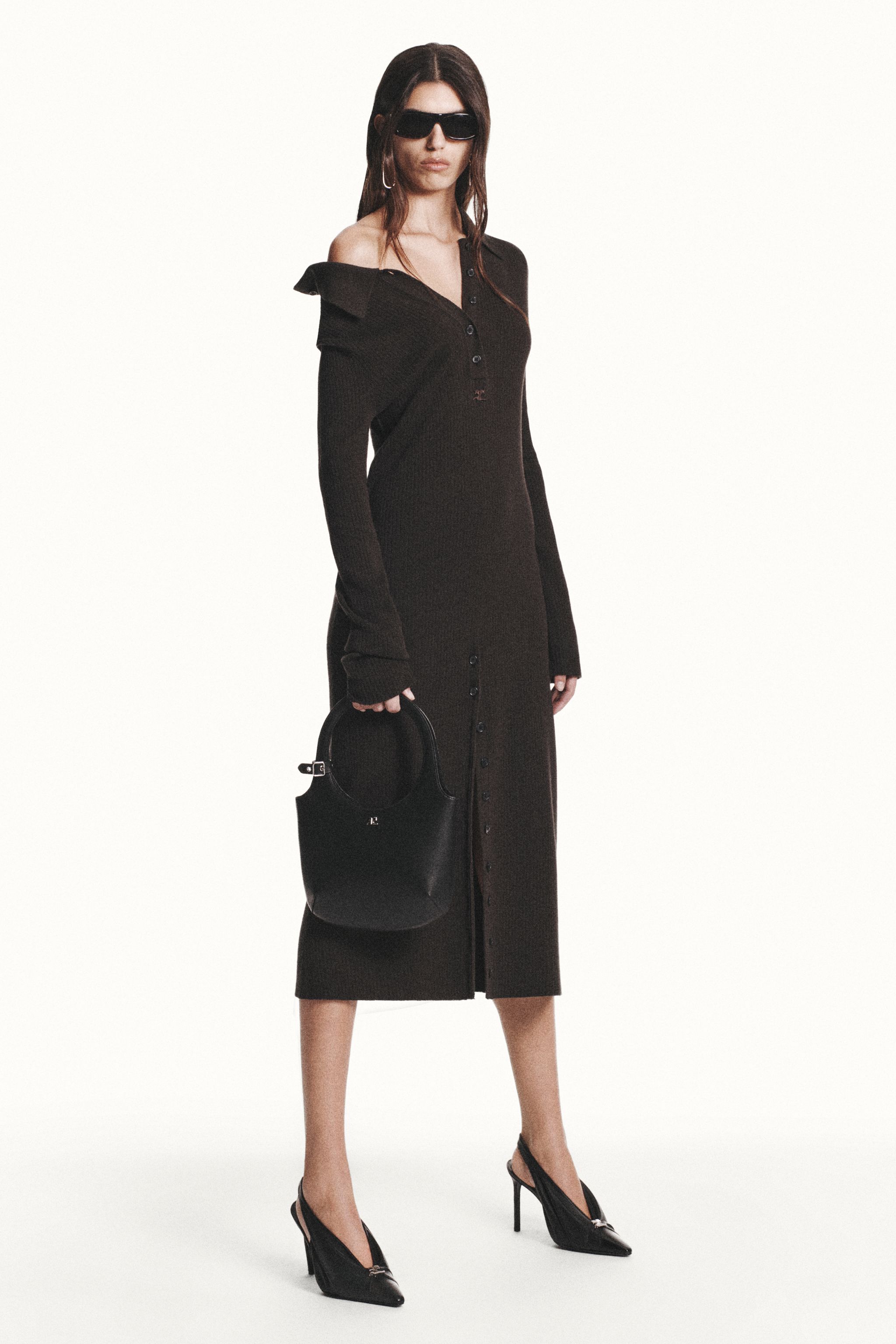 Elegant black dress with a slit, paired with high heels and stylish accessories for Courrèges.