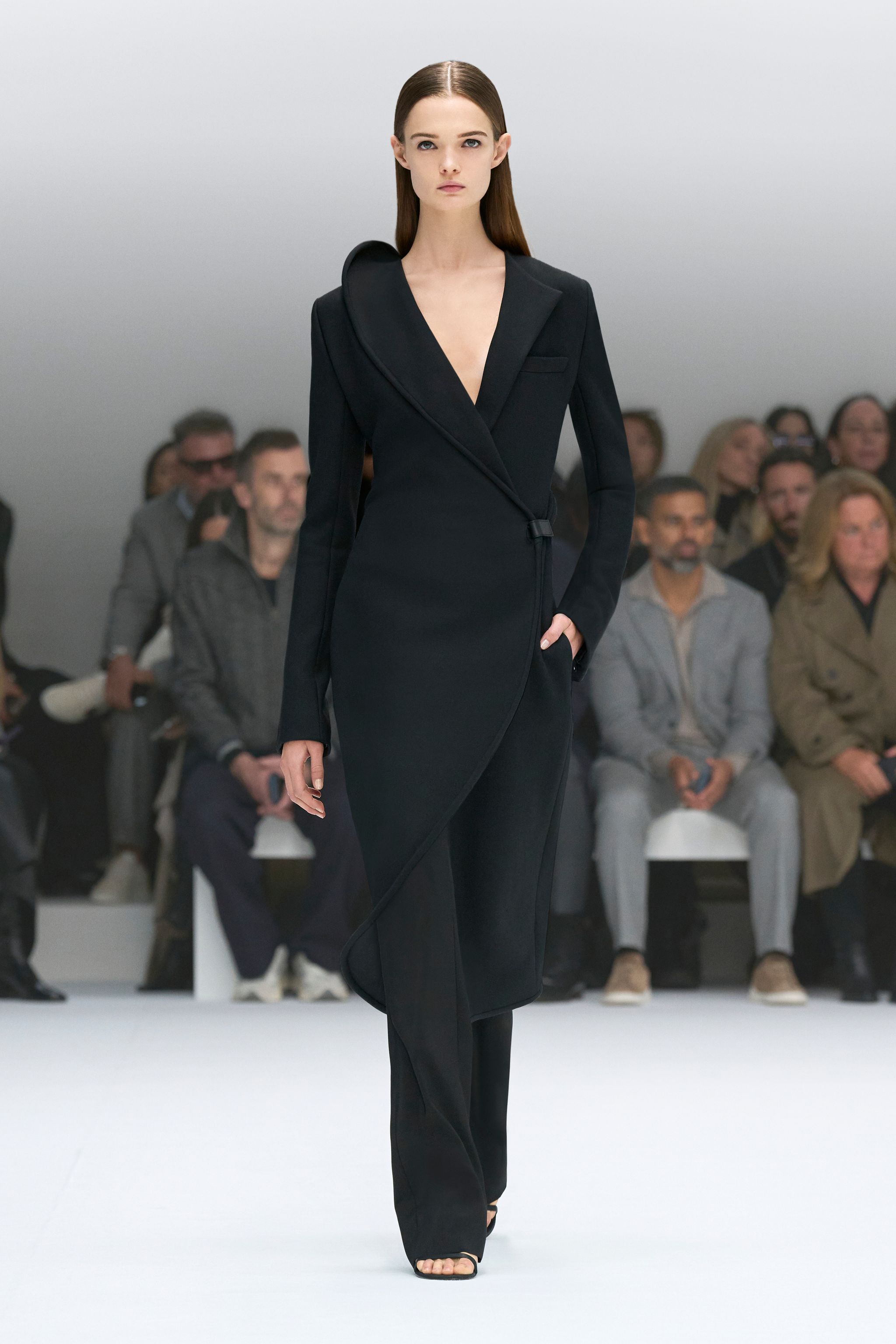 Elegant black dress with a unique hood design, showcased on a runway for Courrèges fashion.