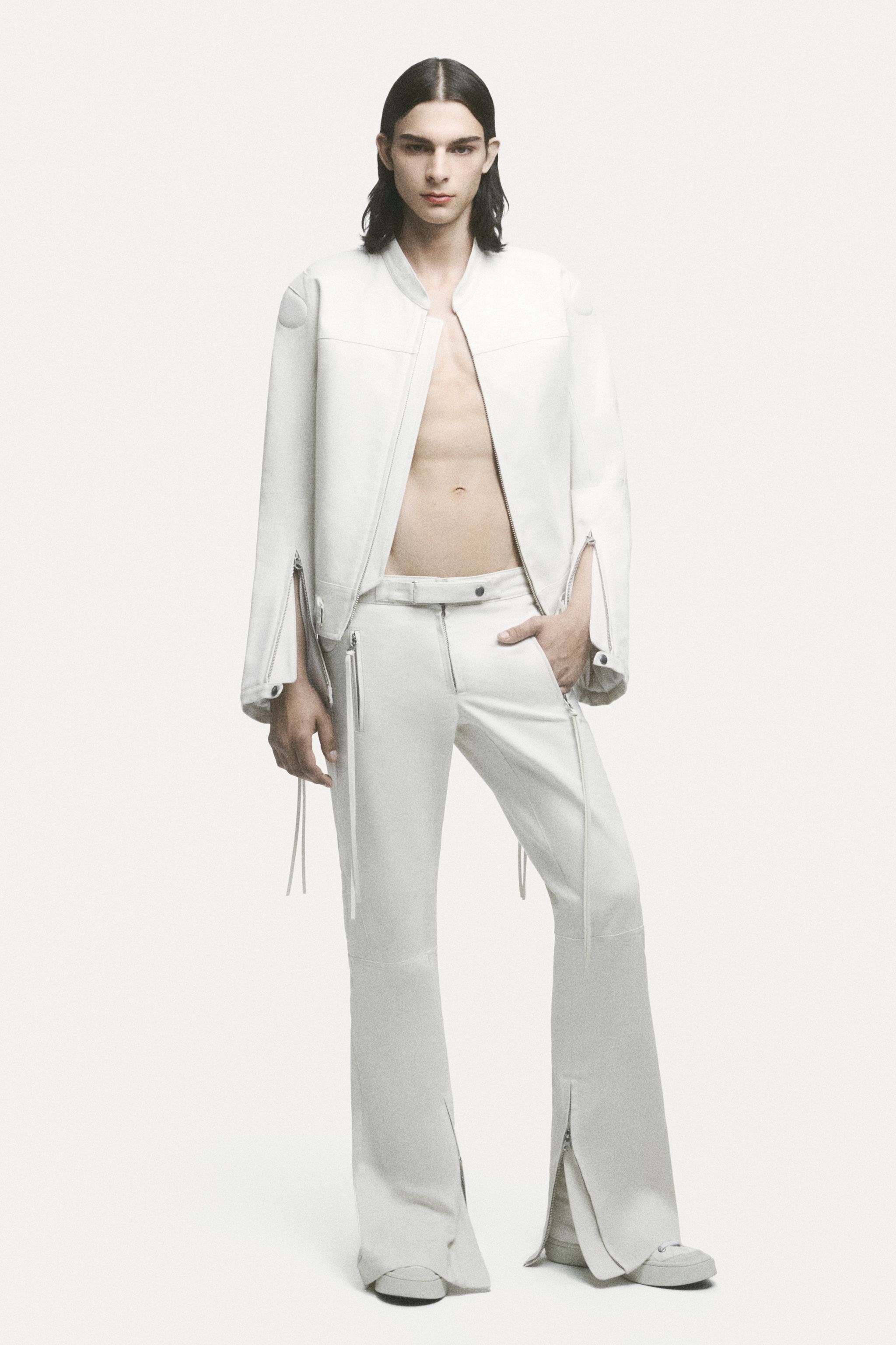 Elegant casual fashion featuring a white oversized sweater, layered with a denim skirt and wide-leg jeans, for Courrèges.