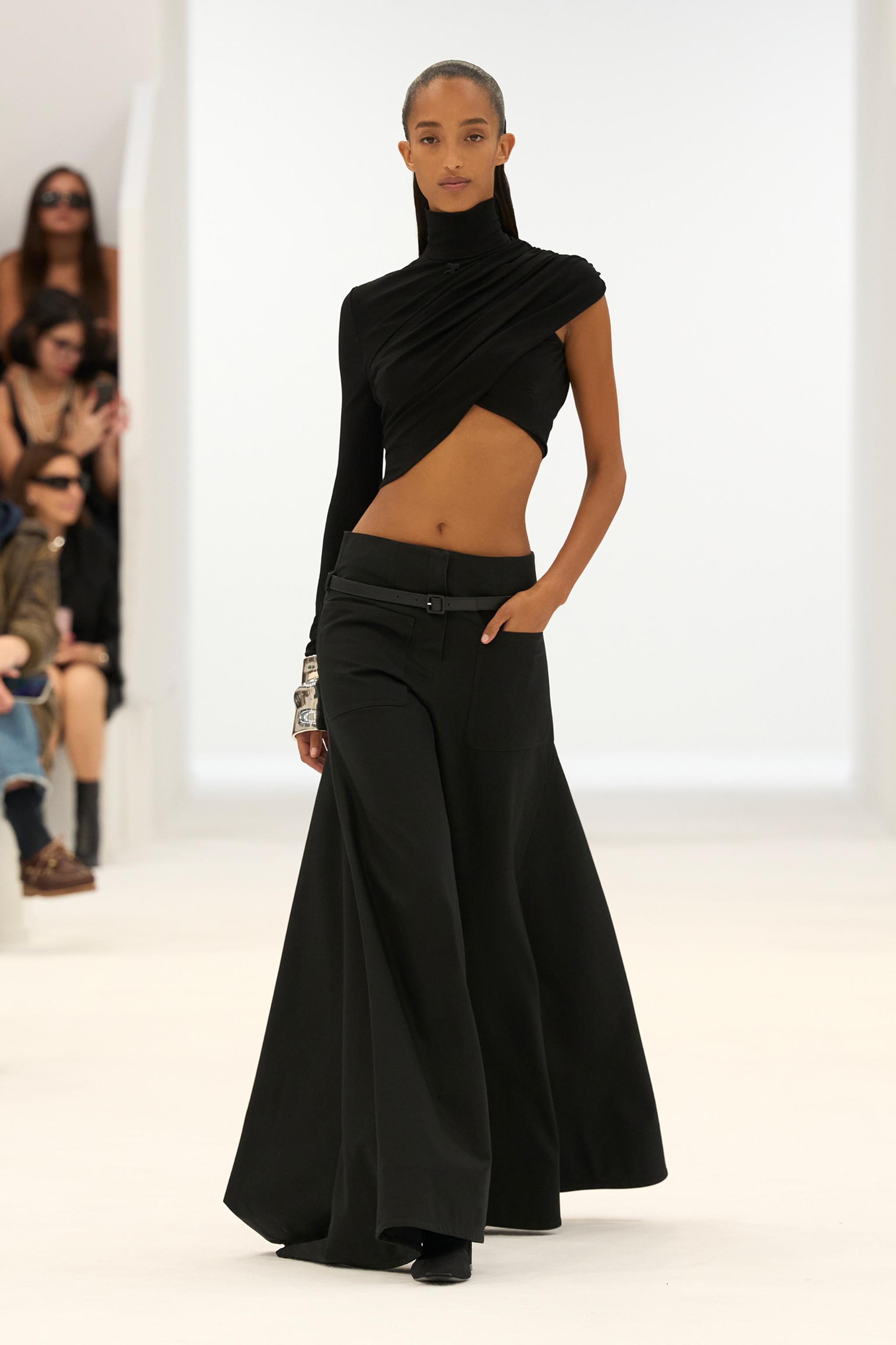 Elegant black asymmetric top with wide-leg pants, showcasing Courrèges' sleek fashion style.