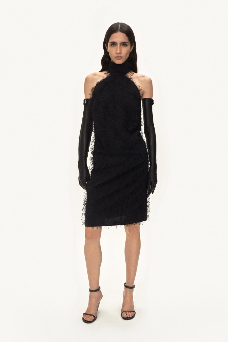 Elegant black dress by Courrèges with textured fabric, paired with long leather gloves and heels.