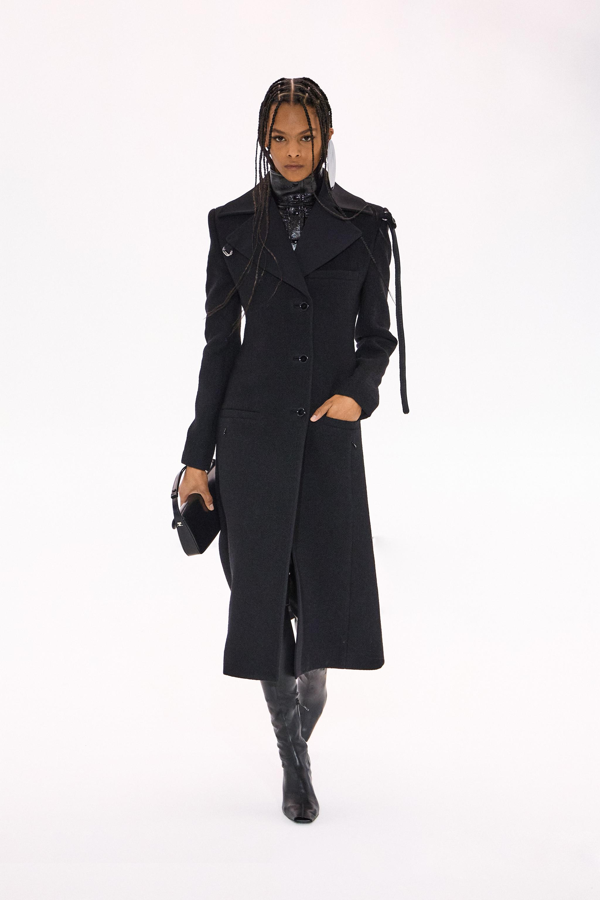 Elegant black overcoat by Courrèges in a sleek, modern style for chic urban fashion.