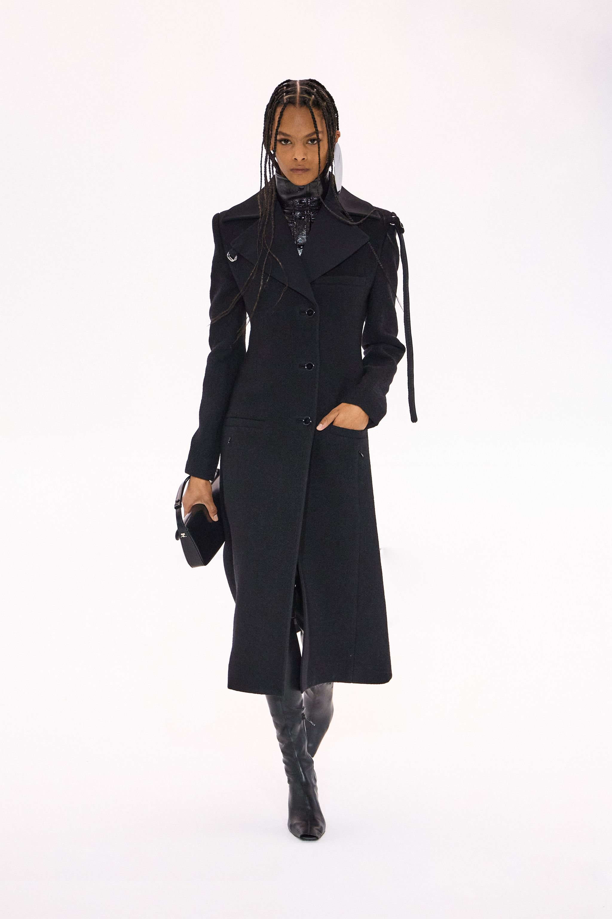 Elegant black trench coat by Courrèges, perfect for a stylish urban look on an ecommerce site.