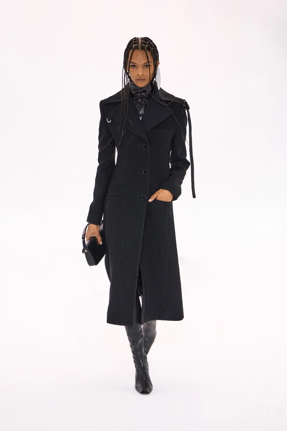 Elegant black trench coat by Courrèges, perfect for a stylish urban look on an ecommerce site.