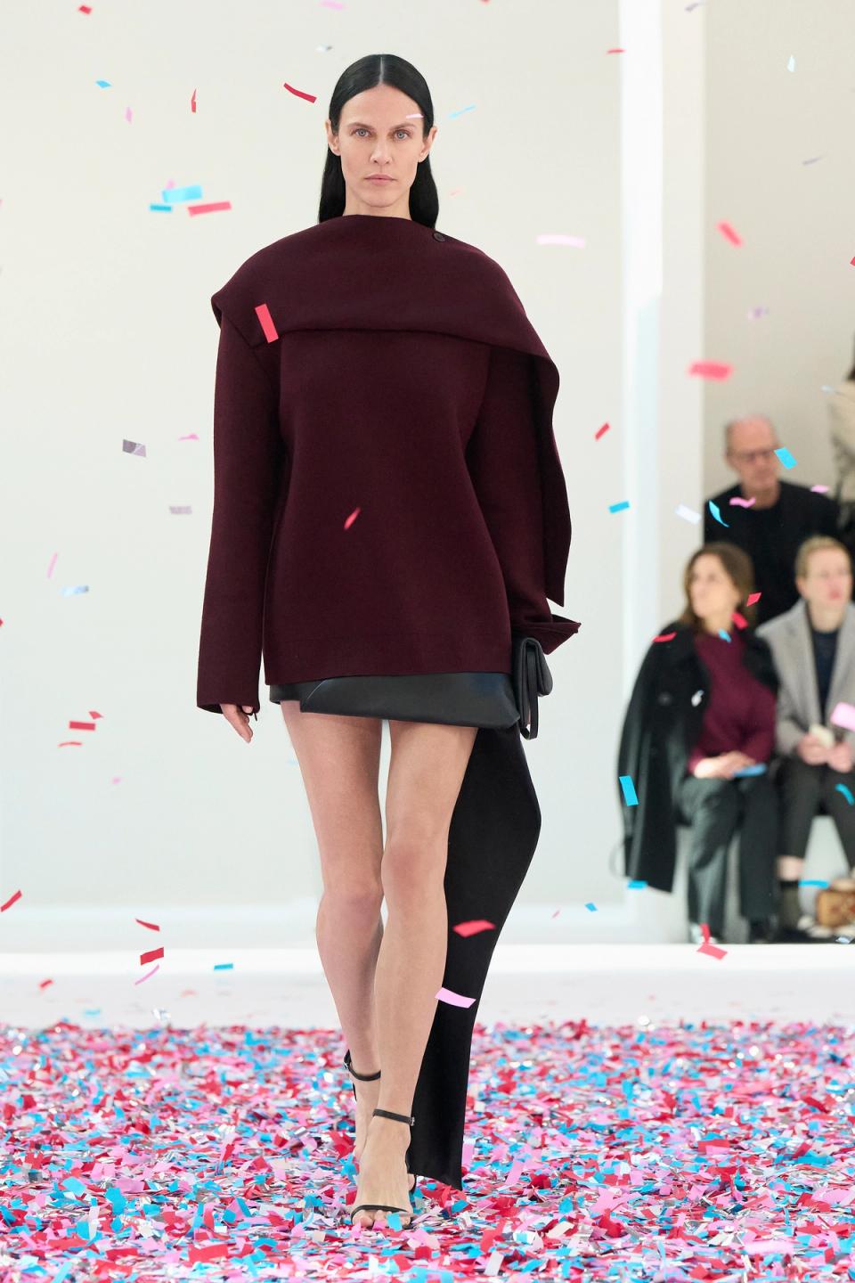 Elegant minimalist burgundy coat and black accessories by Courrèges, fashion runway.
