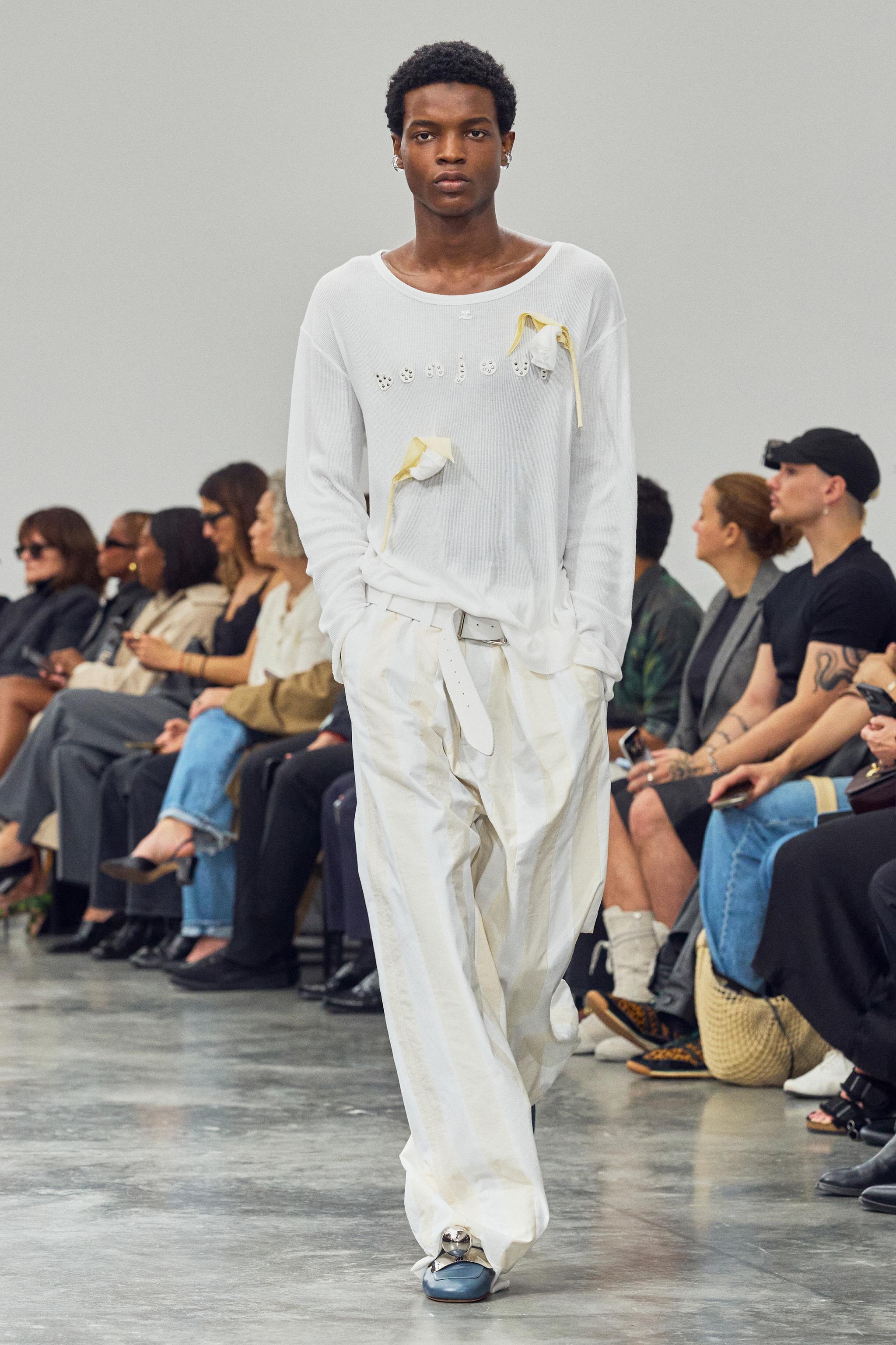 Elegant white couture outfit featuring unique embellishments, showcased by Courrèges.