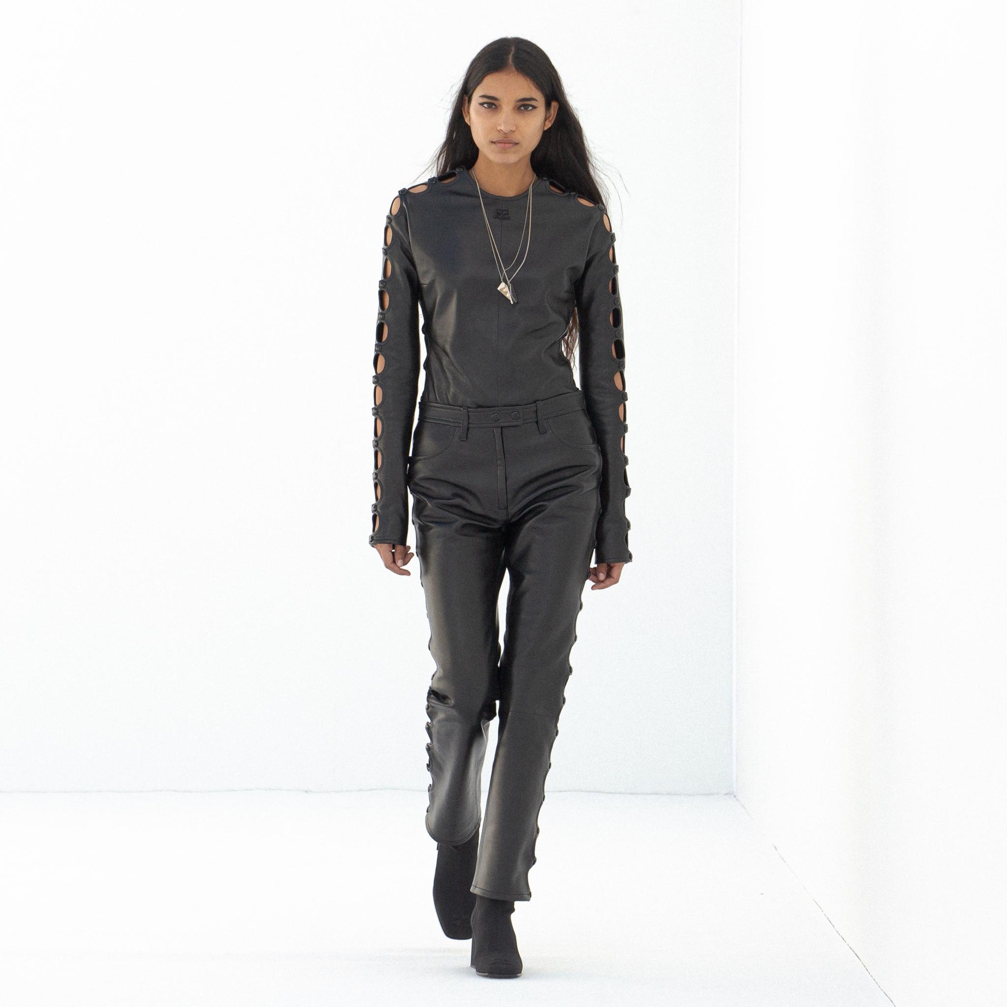 Tenue en cuir noir élégante avec détails à découpes sur les manches, style Courrèges.