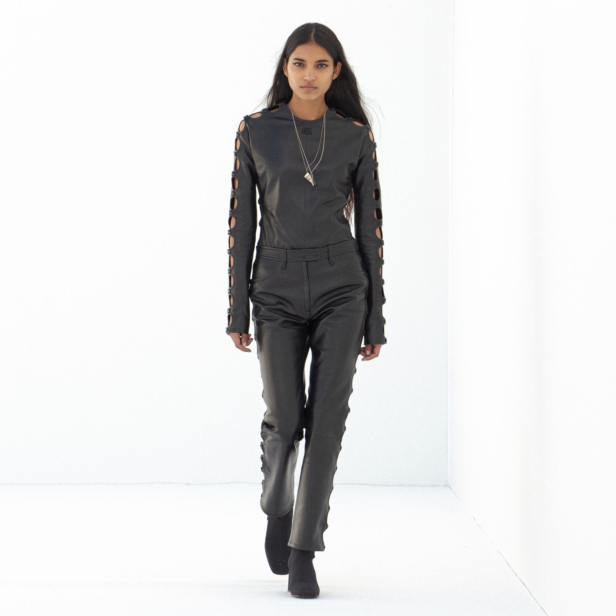 Elegant black leather outfit with cut-out sleeve details, styled for Courrèges fashion.