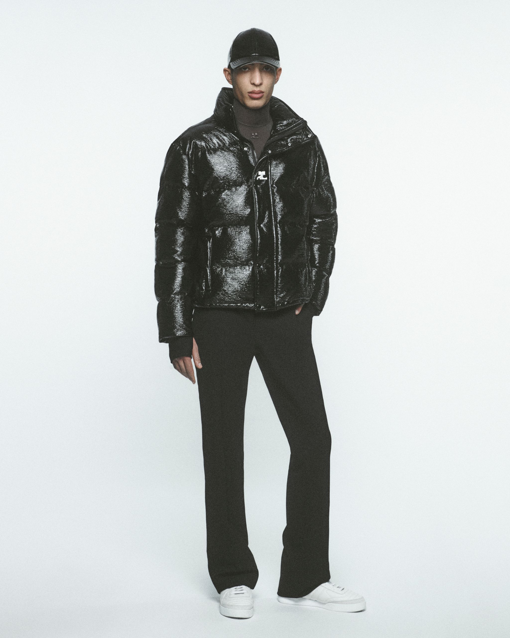 Veste matelassée noire brillante à col haut, portée par un mannequin pour Courrèges.