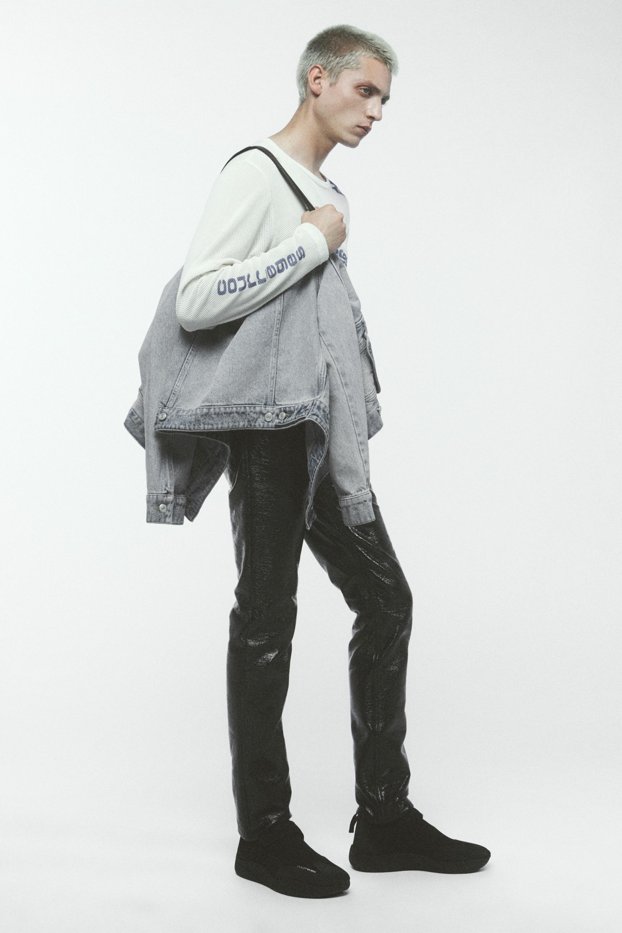 Elegant men's fashion featuring a casual denim jacket, printed sweatshirt, and black sneakers for Courrèges.
