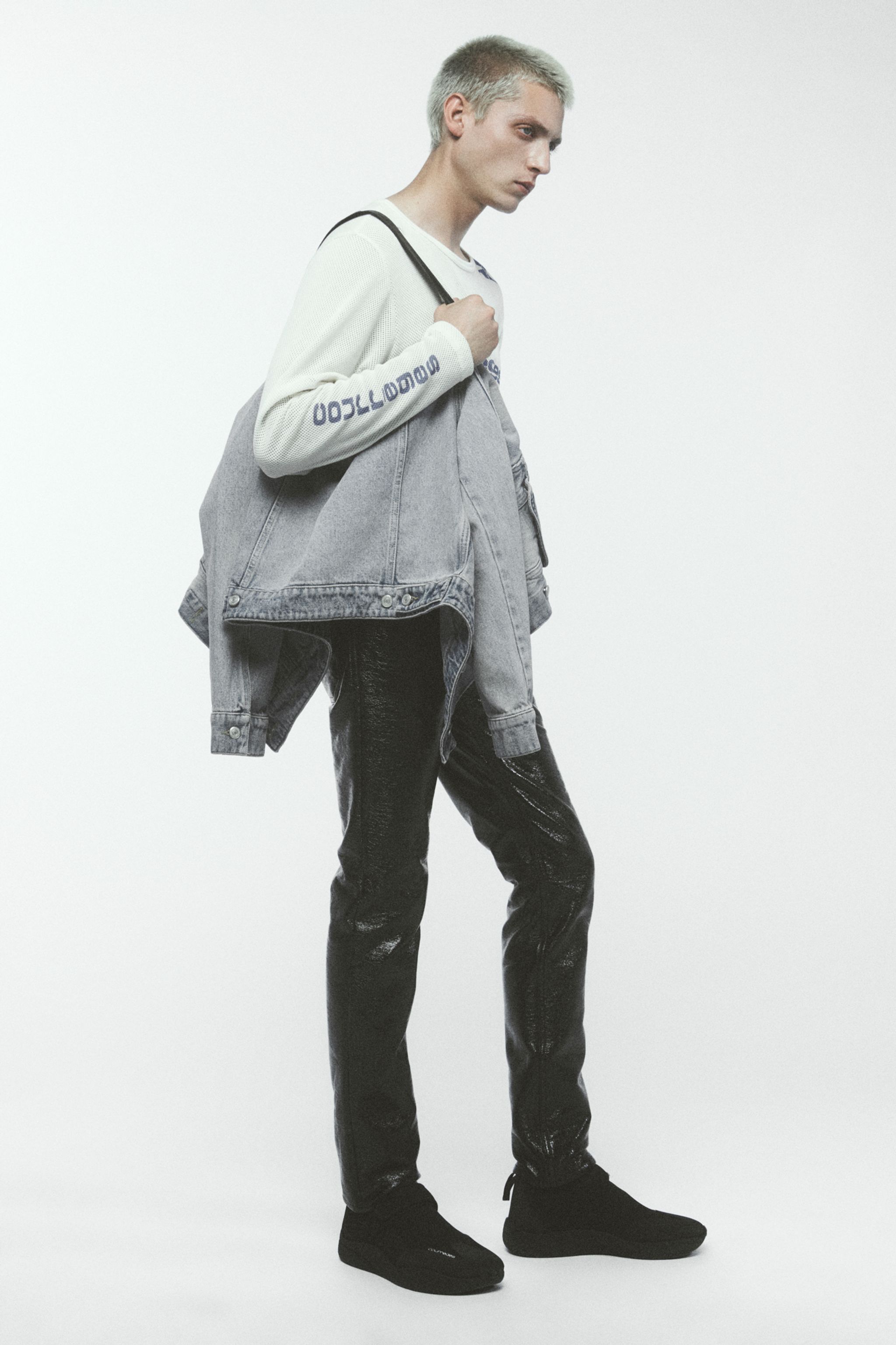 Elegant men's fashion featuring a casual denim jacket, printed sweatshirt, and black sneakers for Courrèges.