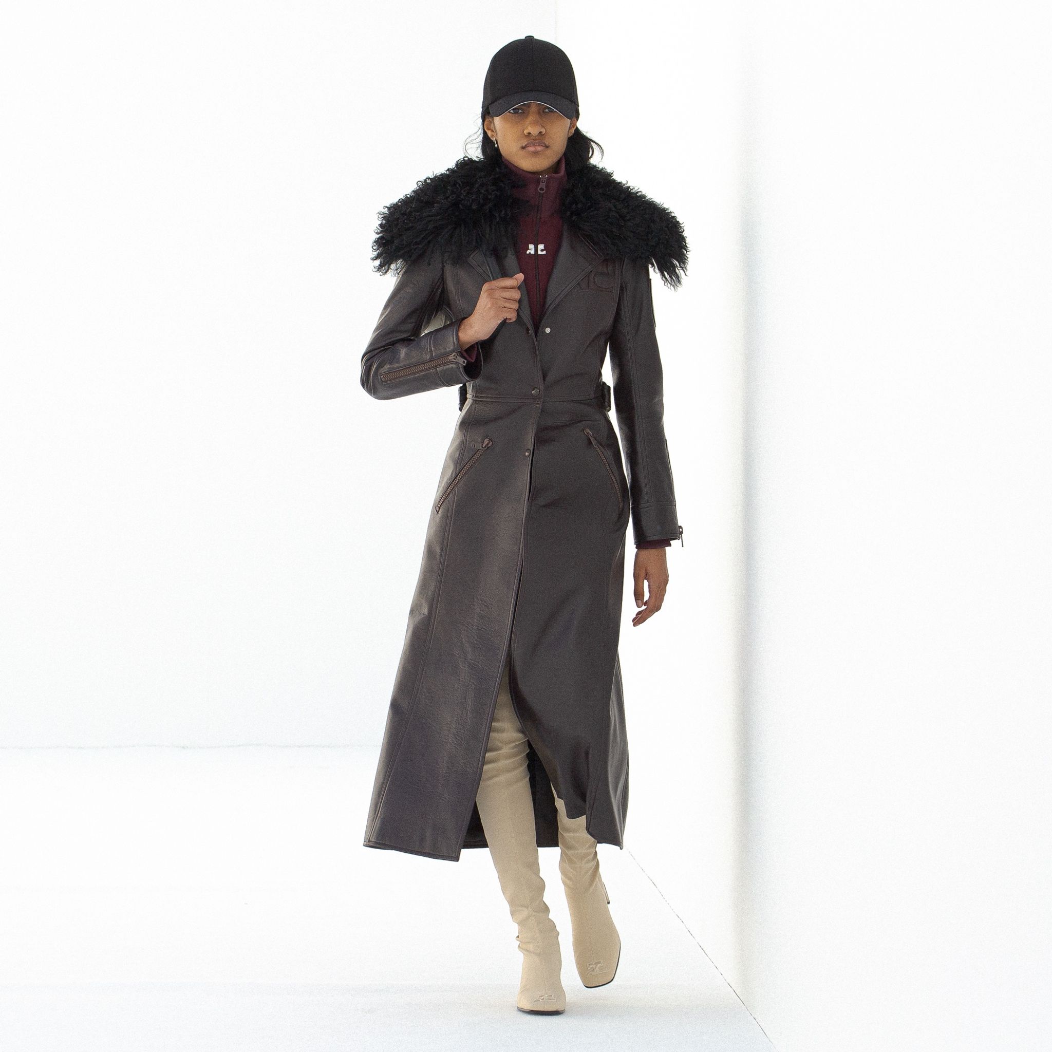 Elegant long leather coat with fur collar by Courrèges, perfect for a chic winter look.