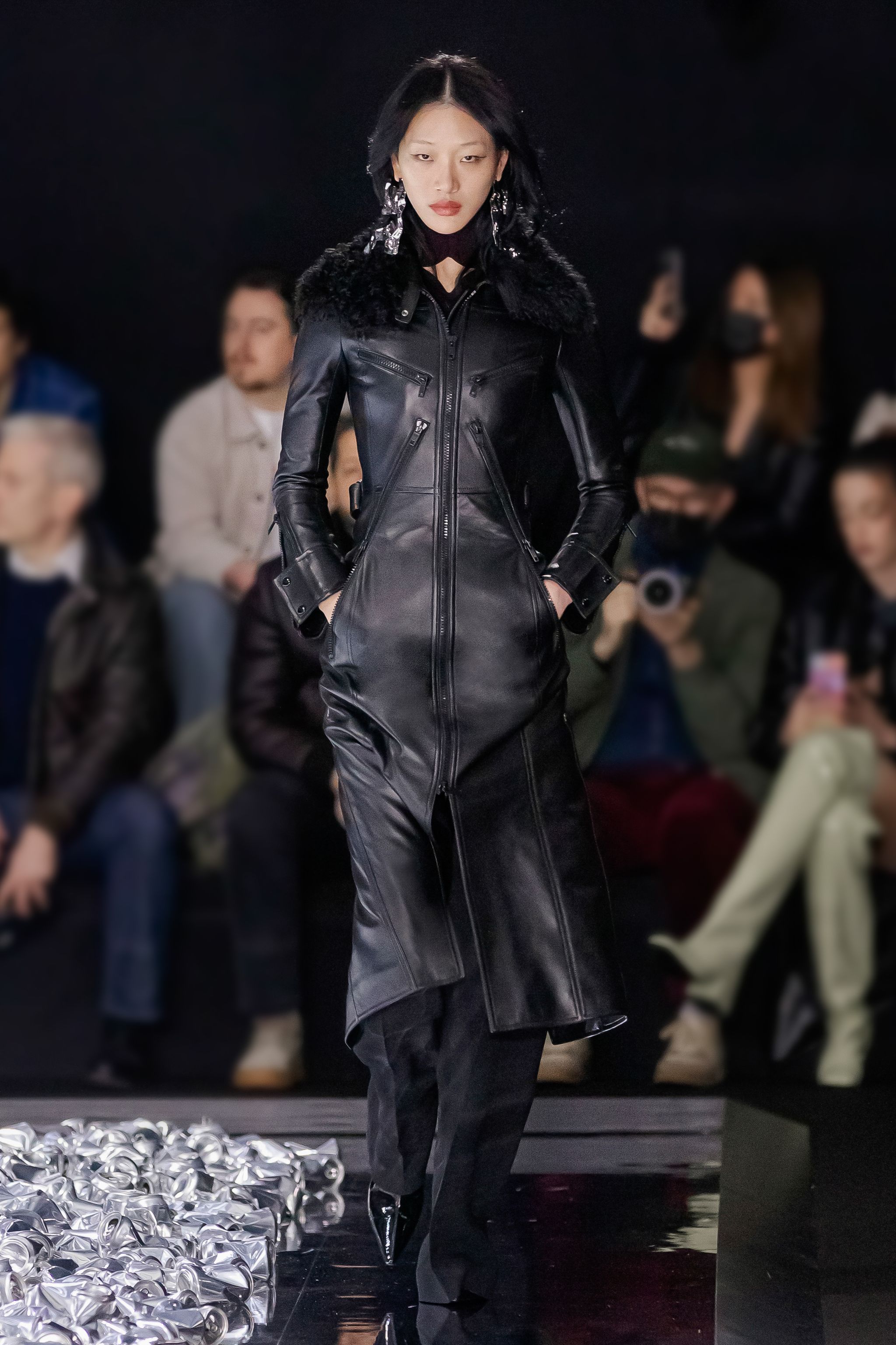 Elegant black leather coat with fur collar showcased at Courrèges fashion show, perfect for modern style.
