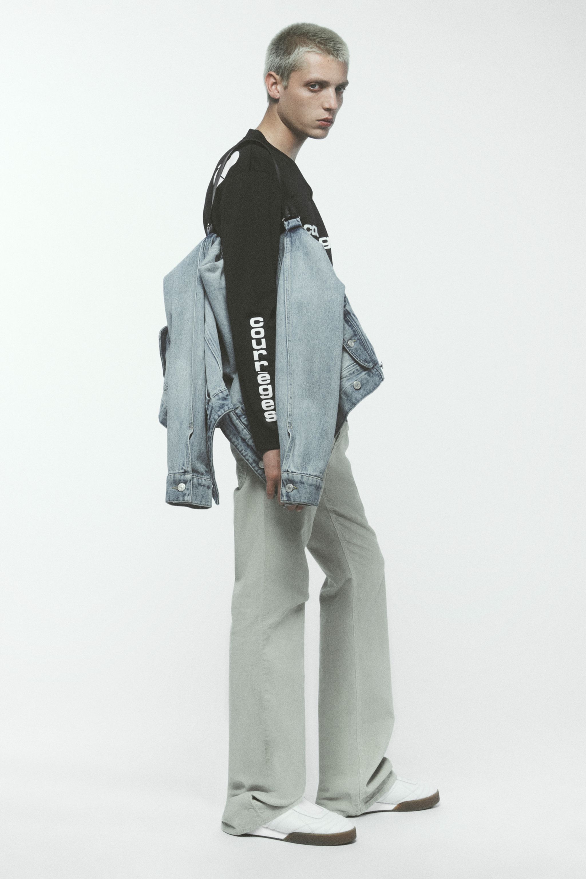 Elegant Courrèges fashion model showcasing denim jacket, sweatshirt, and wide-leg pants.