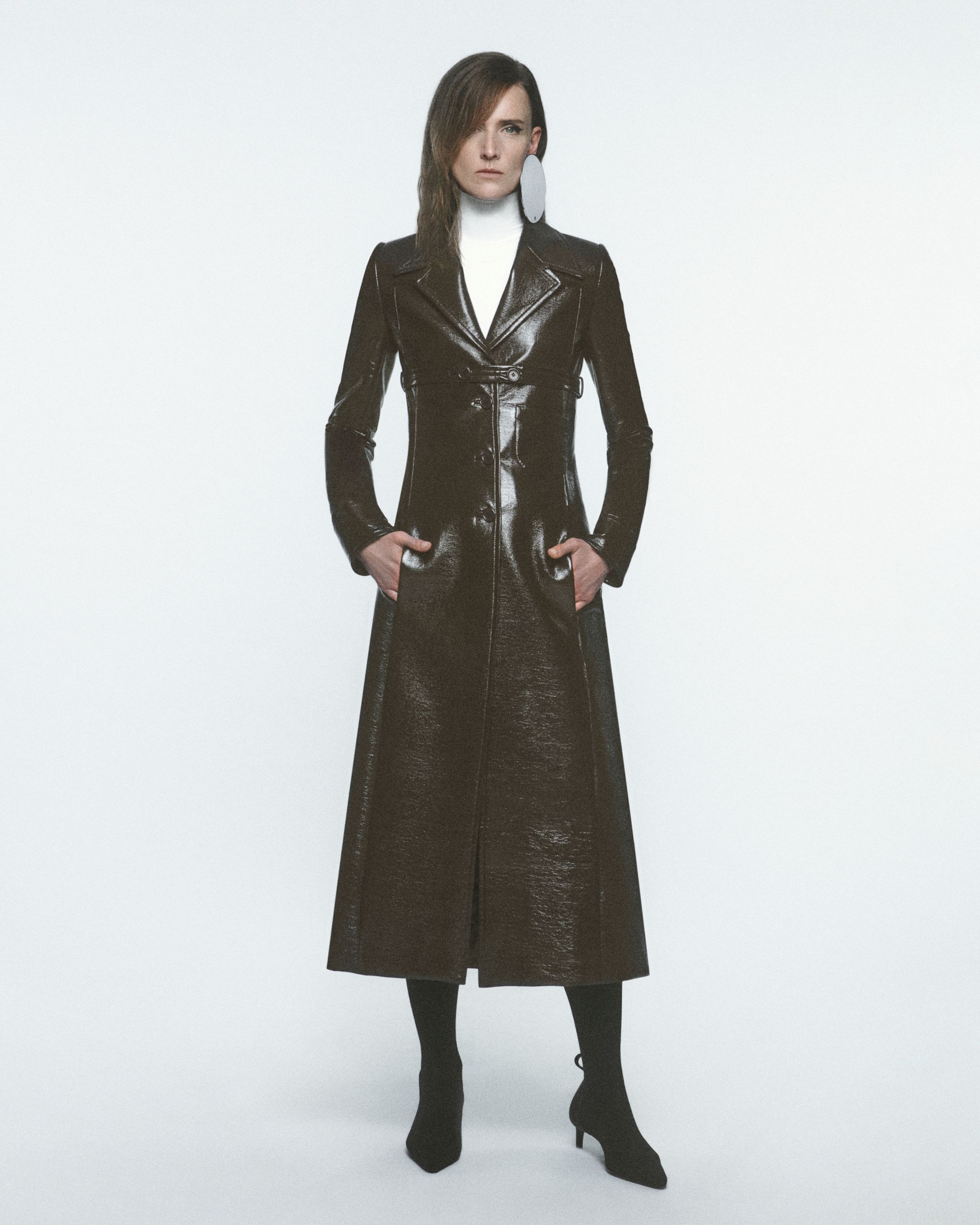 Manteau en cuir noir longue et élégant de Courrèges, ajusté avec une finition métallique.