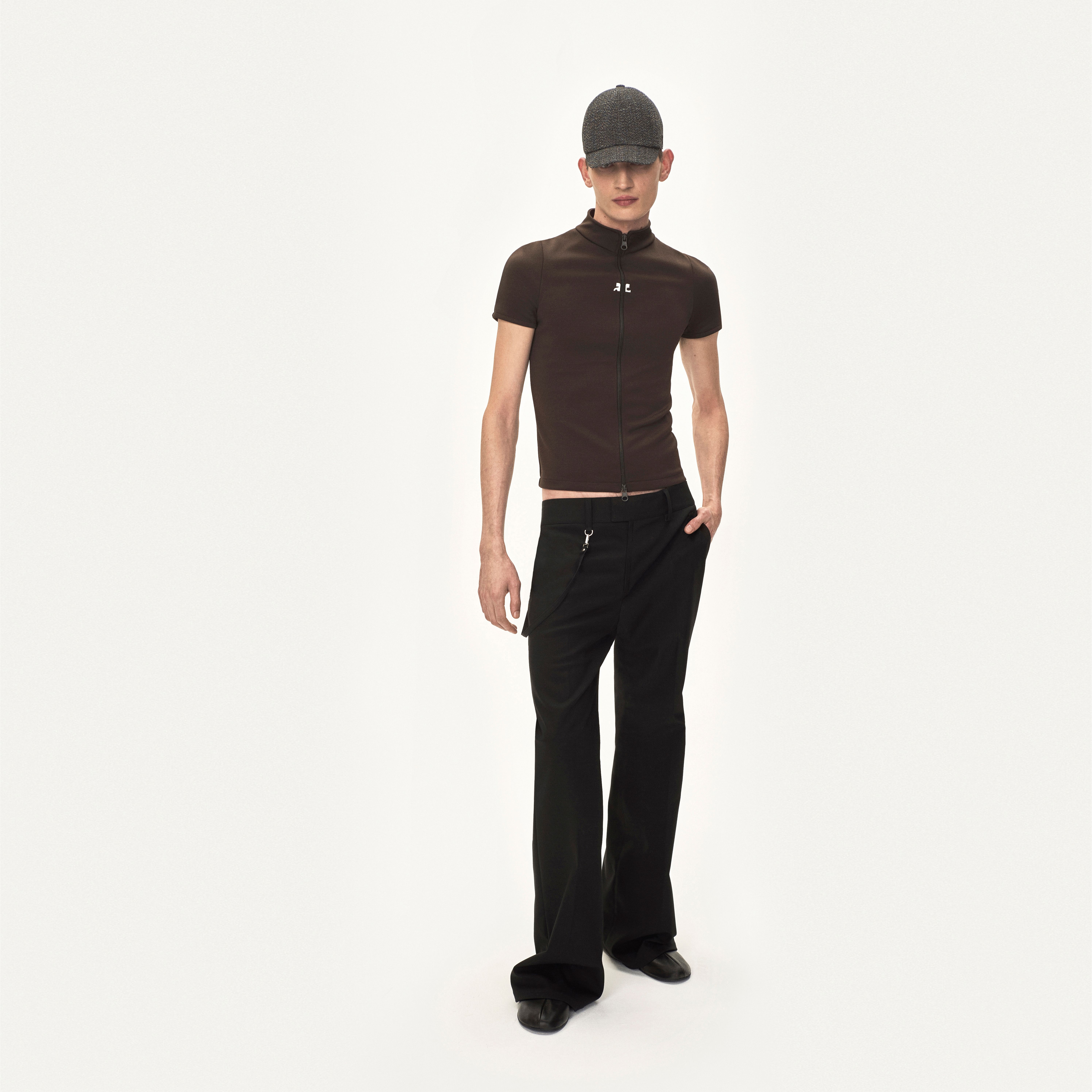Elegant women’s fashion featuring a fitted brown zip-up top and black wide-leg trousers.
