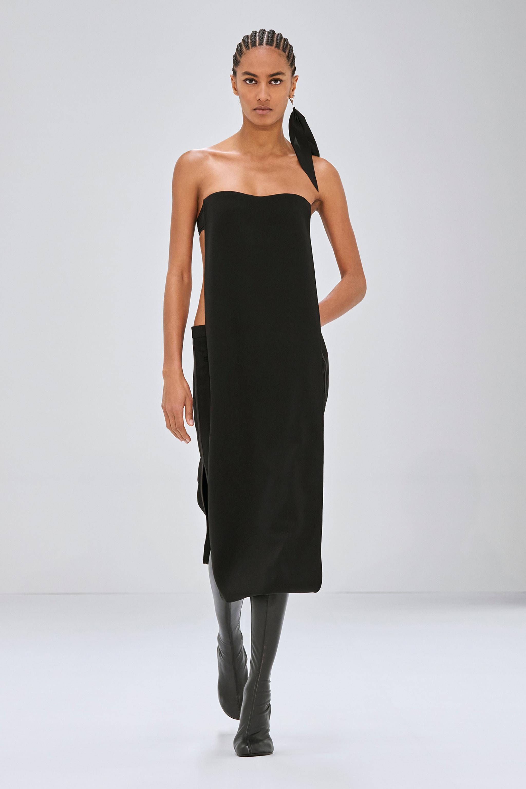 Robe noire strapless élégante de Courrèges, présentée sur un mannequin pour le site de mode.