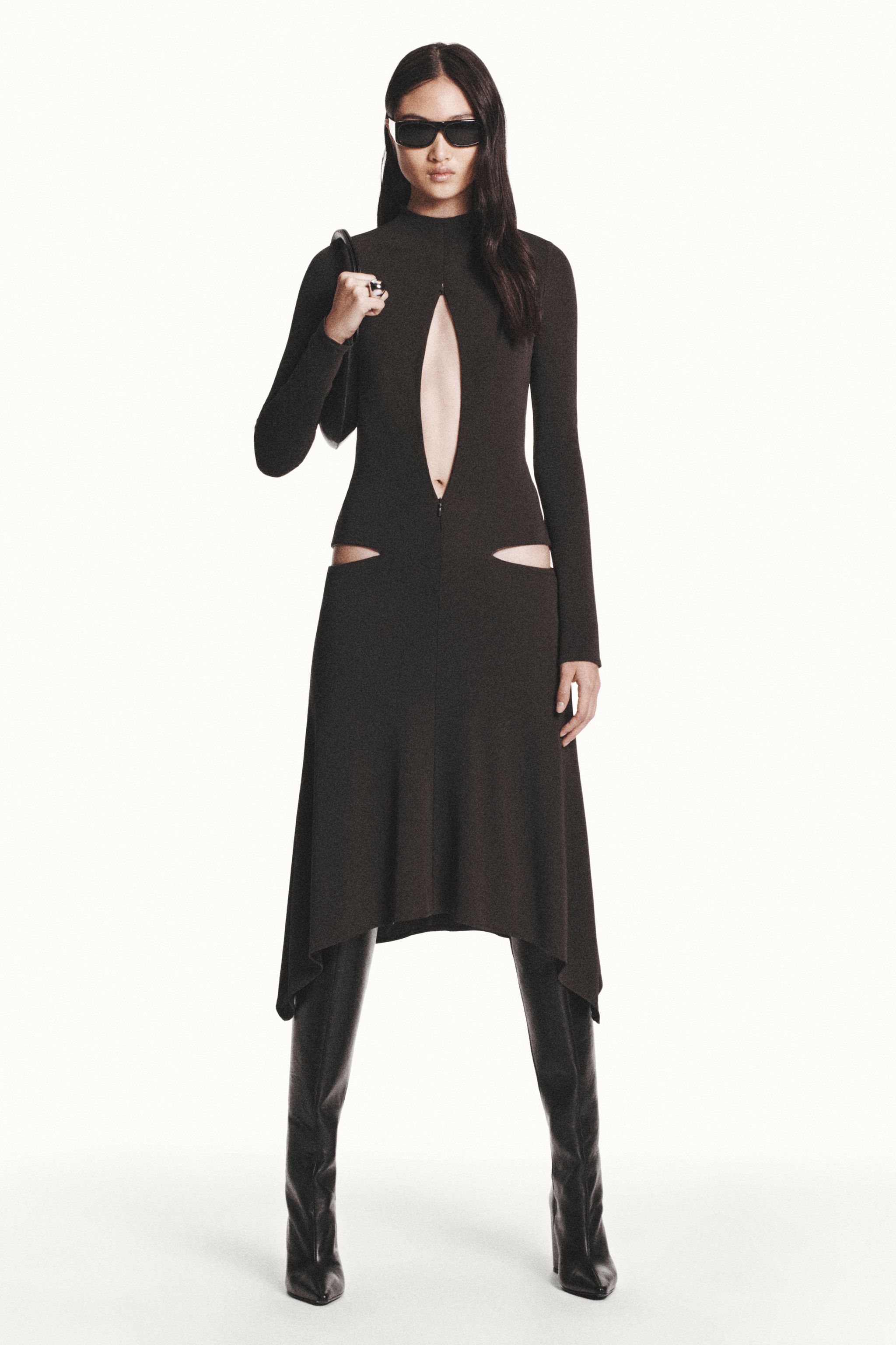 Elegant black Courrèges dress with cut-outs, long sleeves, and fashionable sunglasses.
