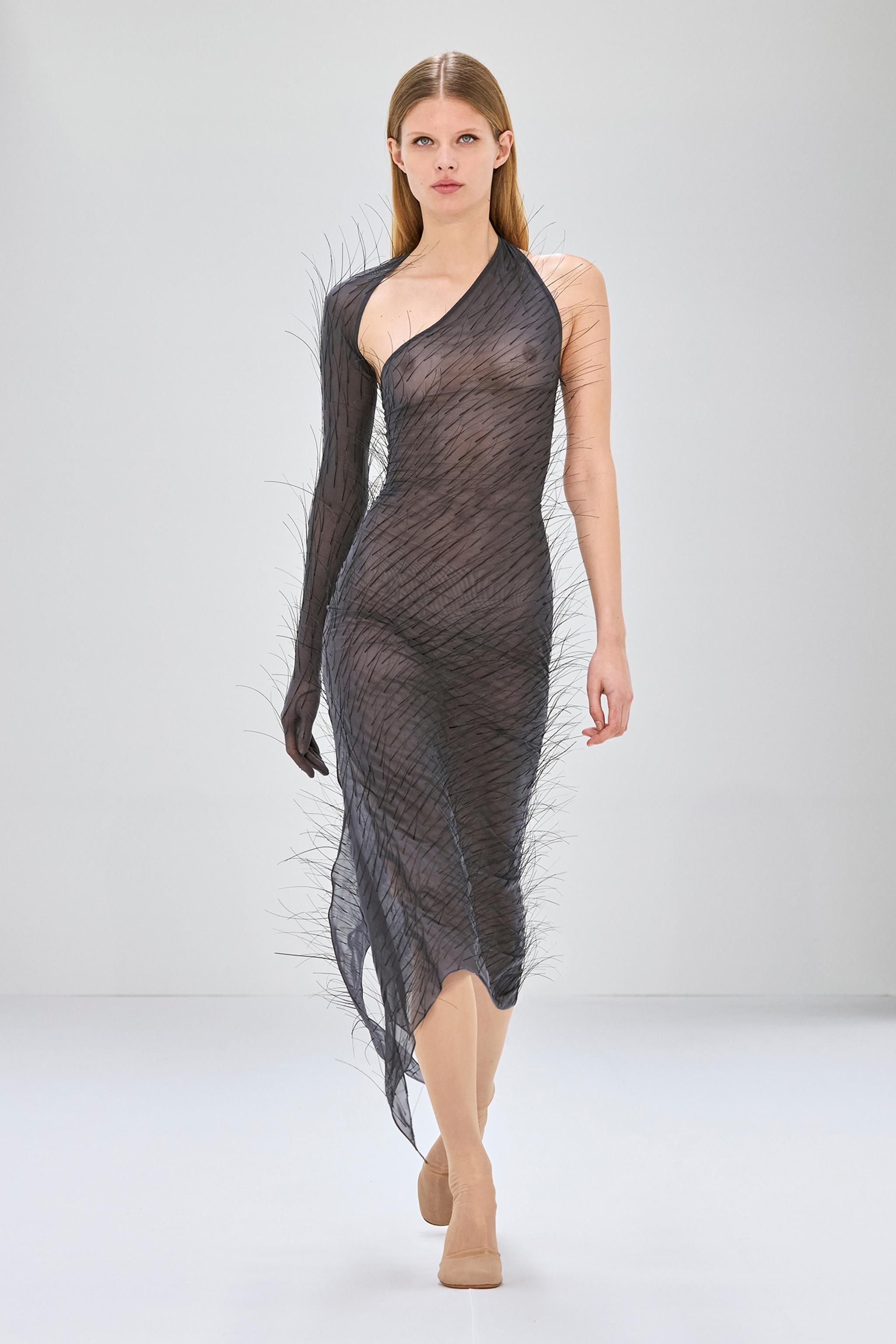 Robe noire transparente avec détails plumes, conçue par Courrèges pour les passionnés de mode.