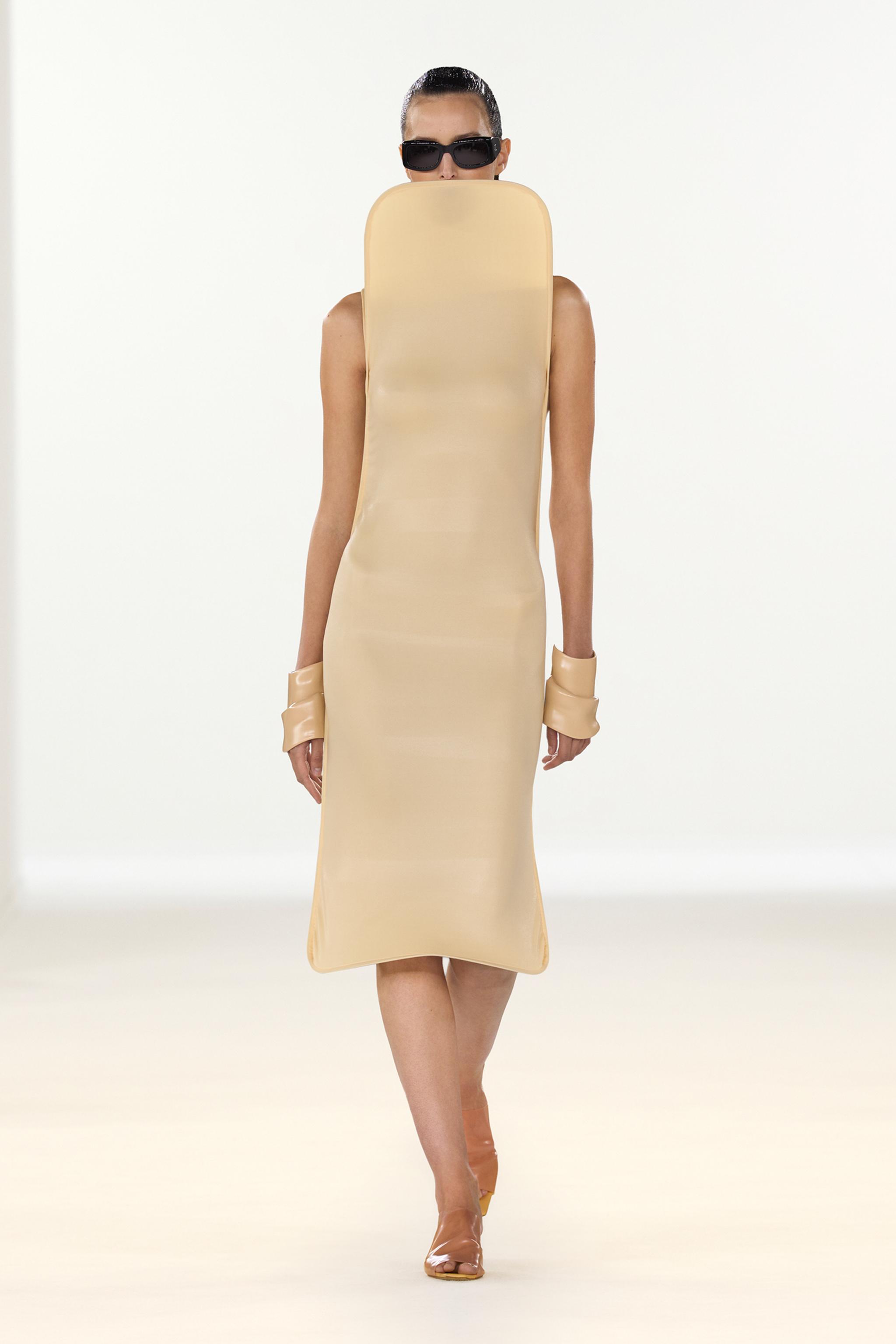 Elegant fashion model wearing a beige sculptural dress with sunglasses on an ecommerce site for Courrèges.
