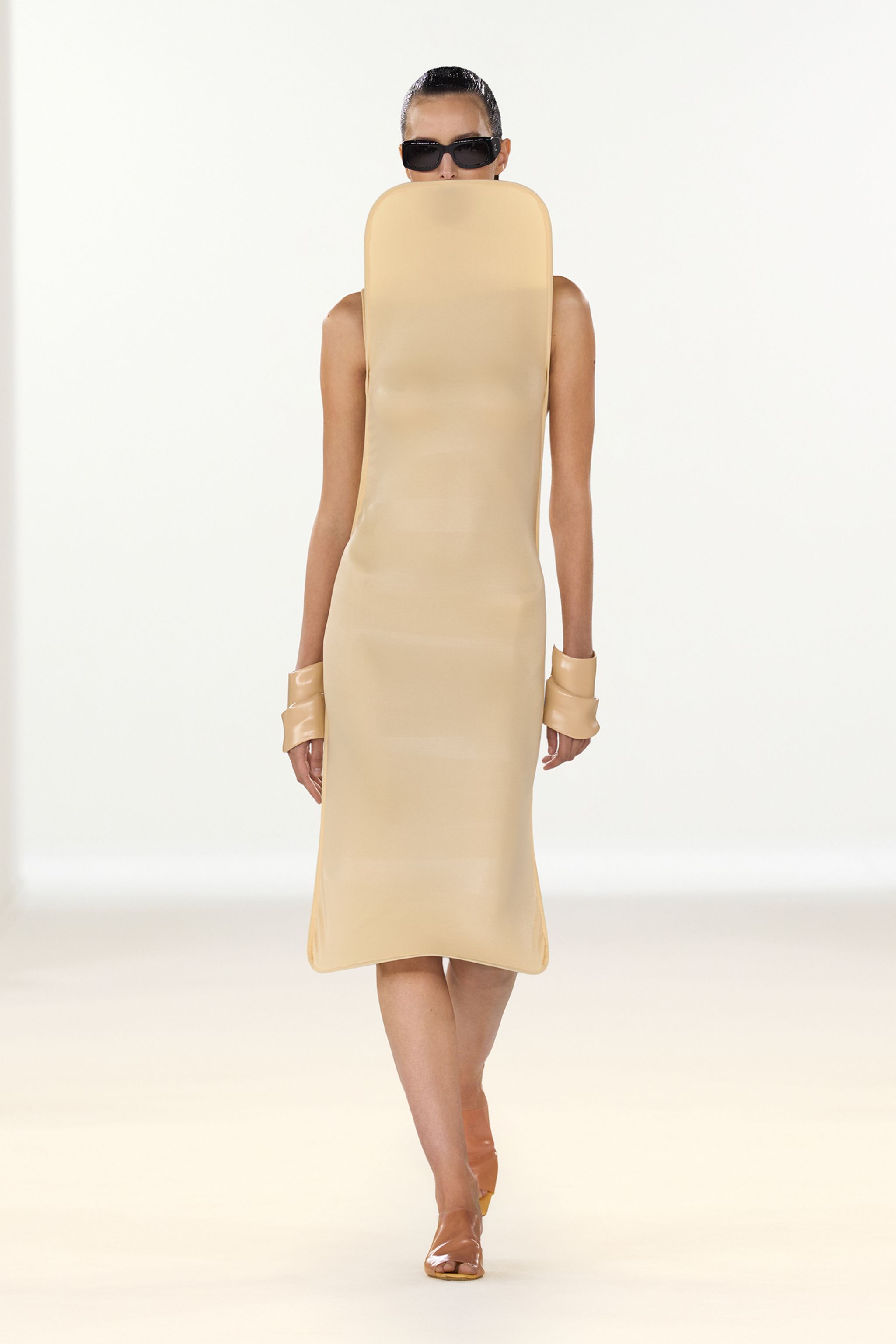 Elegant beige dress by Courrèges, featuring a sleek, modern silhouette and minimalist design.