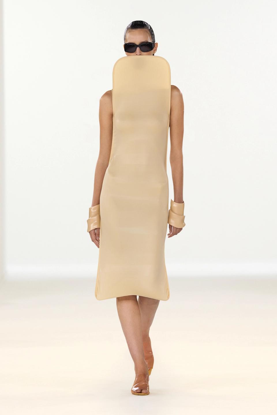 Elegant beige dress by Courrèges, featuring a sleek, modern silhouette and minimalist design.