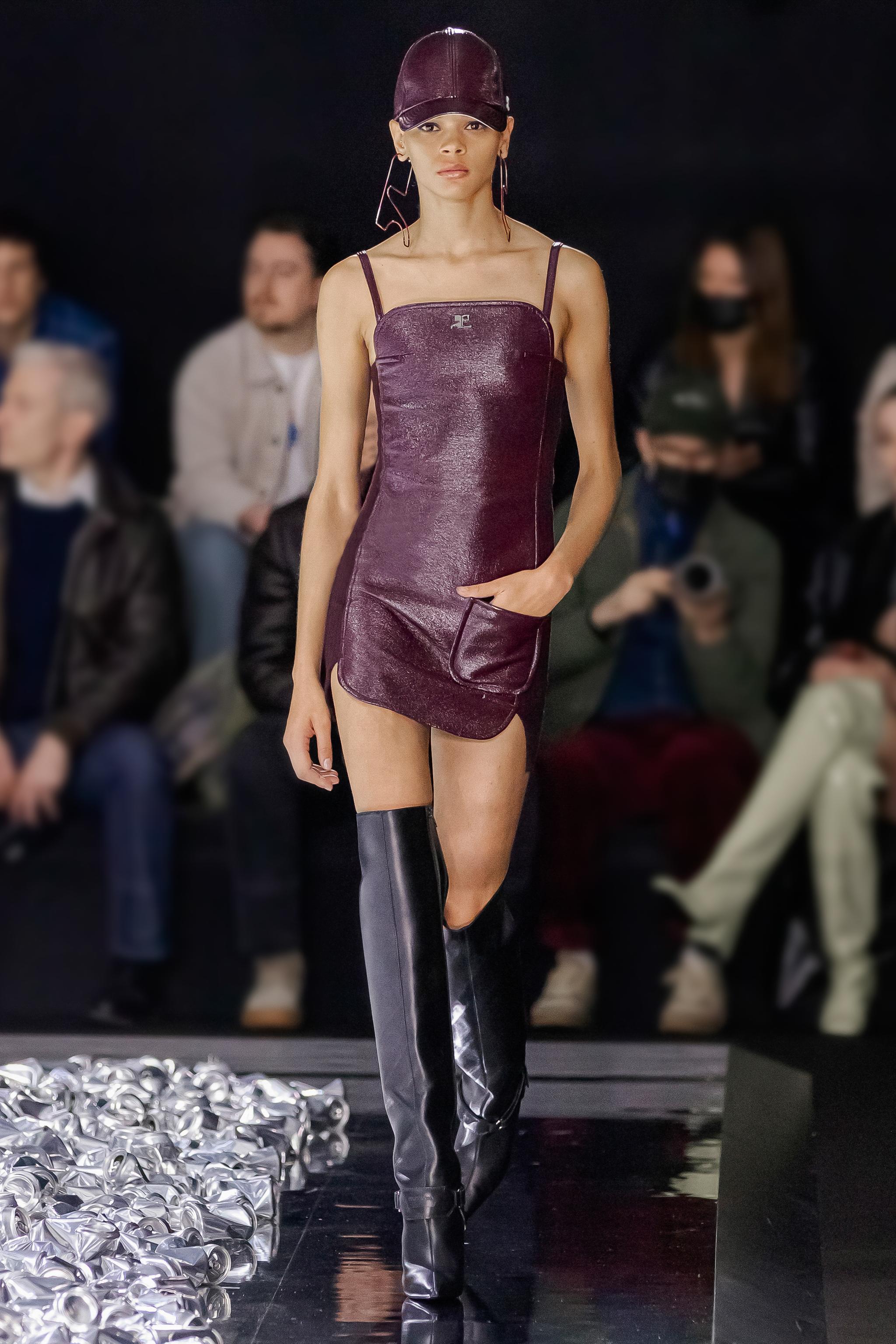 Elegant purple leather mini dress with thin straps, on a runway for Courrèges fashion brand.