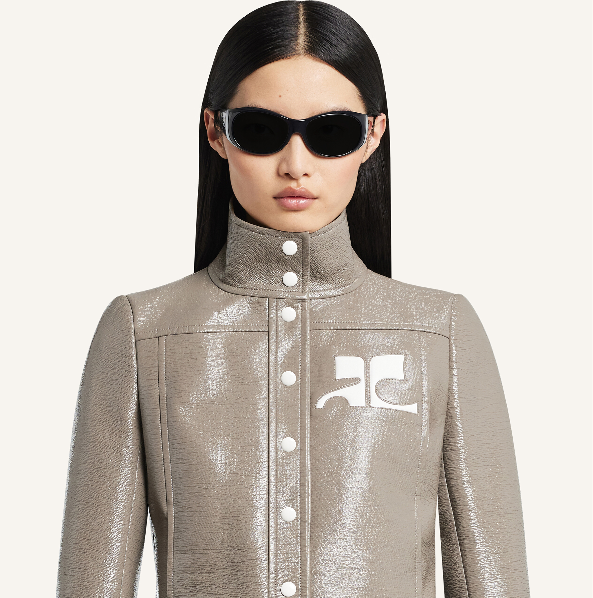 Elegant model wearing Courrèges metallic jacket and sunglasses, showcasing modern fashion.