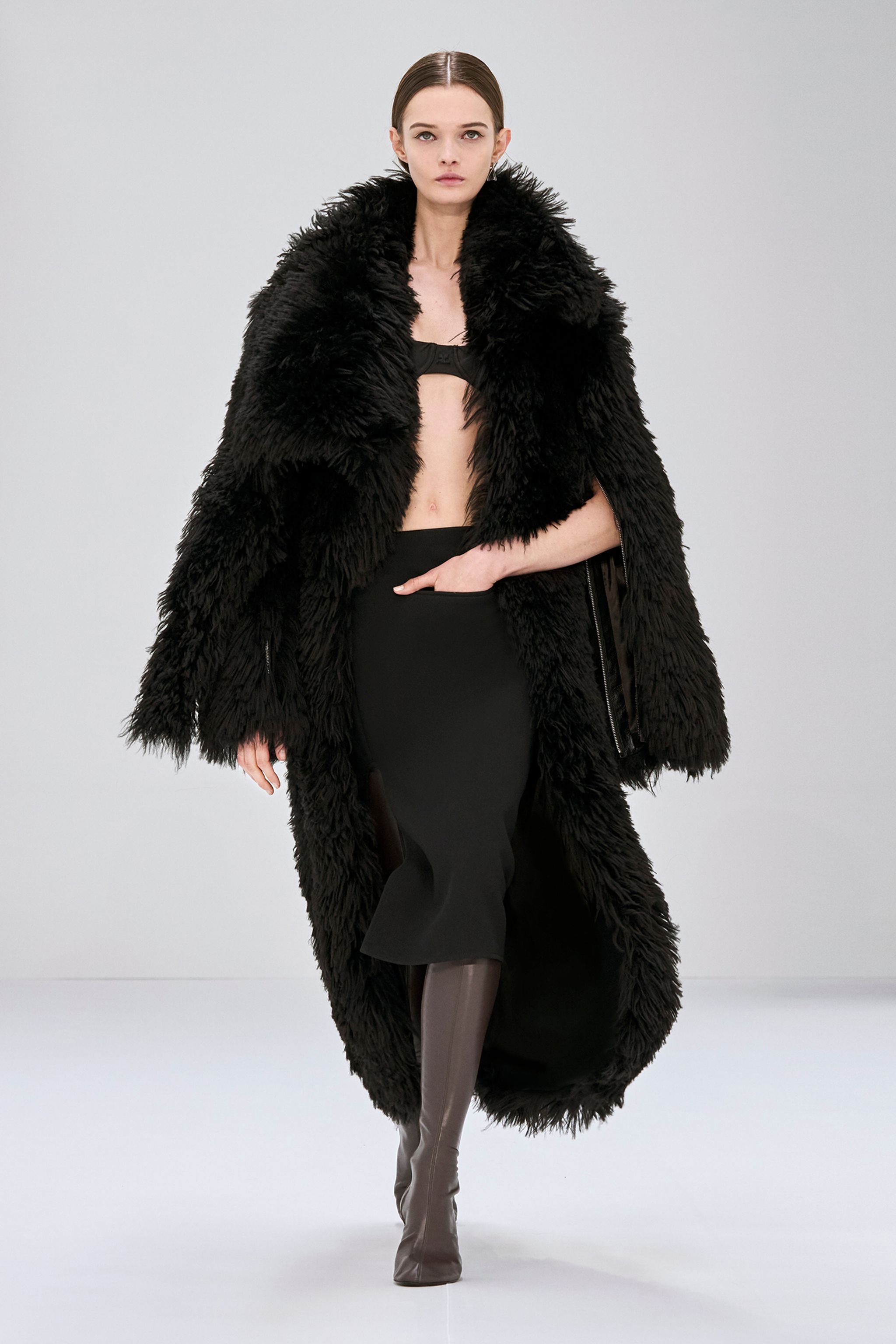 Elegant black faux fur coat from Courrèges, showcasing high fashion on the runway.