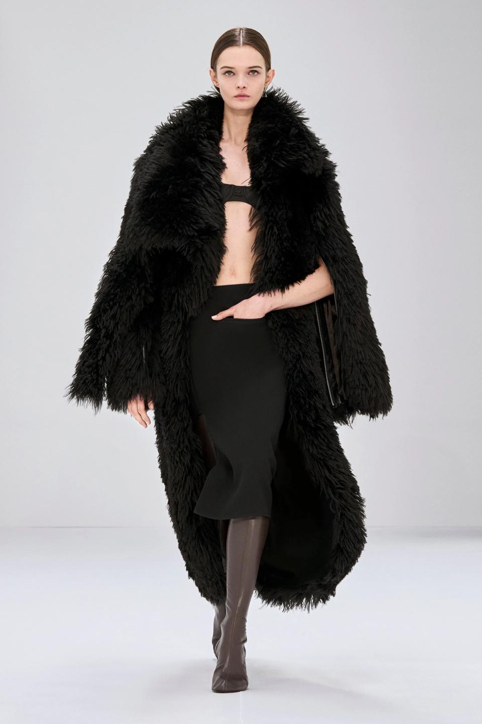 Elegant black faux fur coat from Courrèges, showcasing high fashion on the runway.