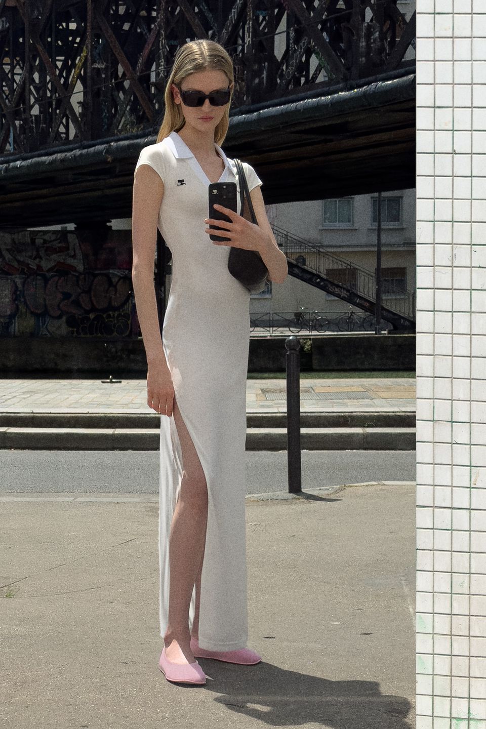 Elegant white dress with a slit, styled with pink shoes and Courrèges branding for fashion lovers.