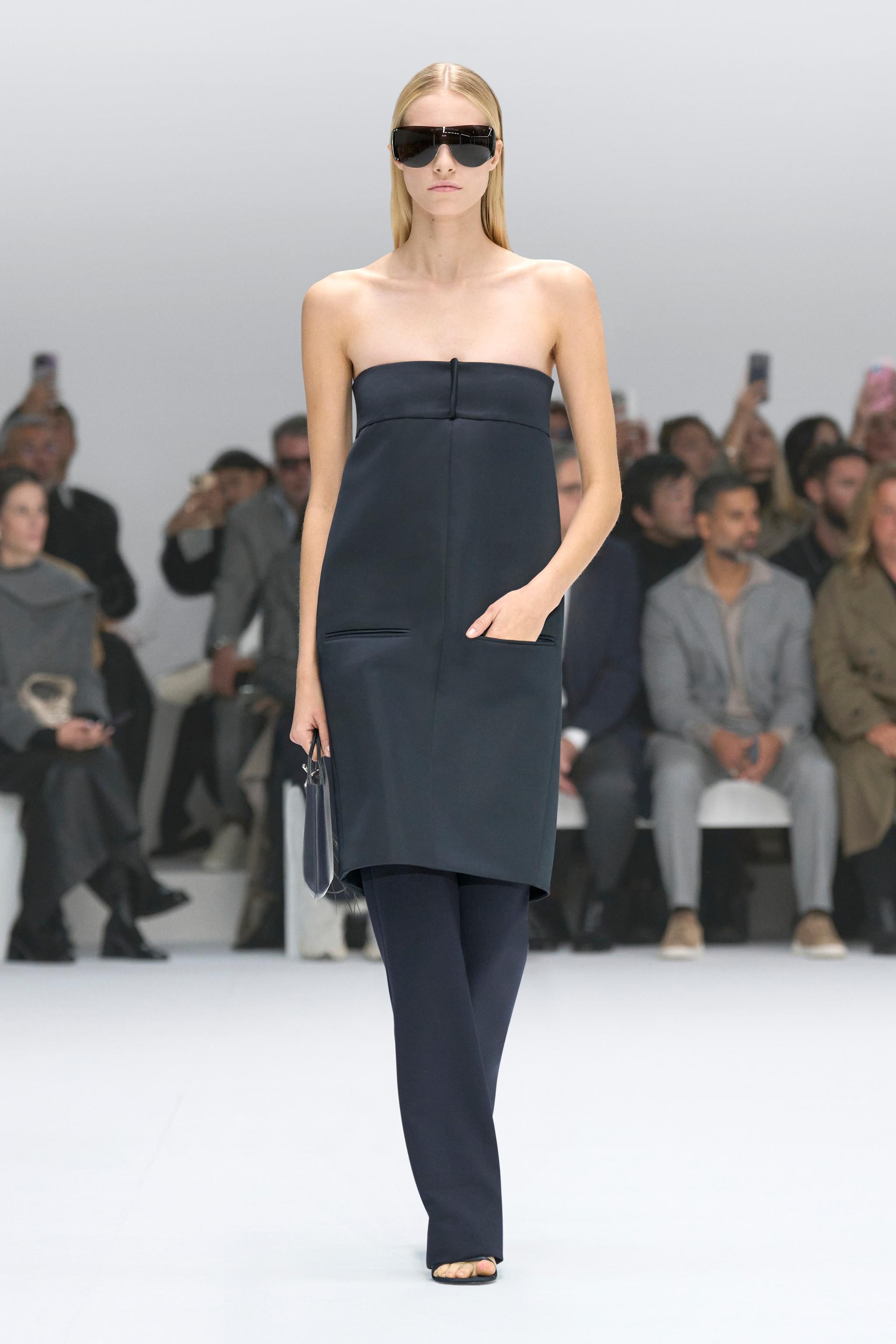 Elegant black strapless dress and accessories by Courrèges on runway for a fashion show.