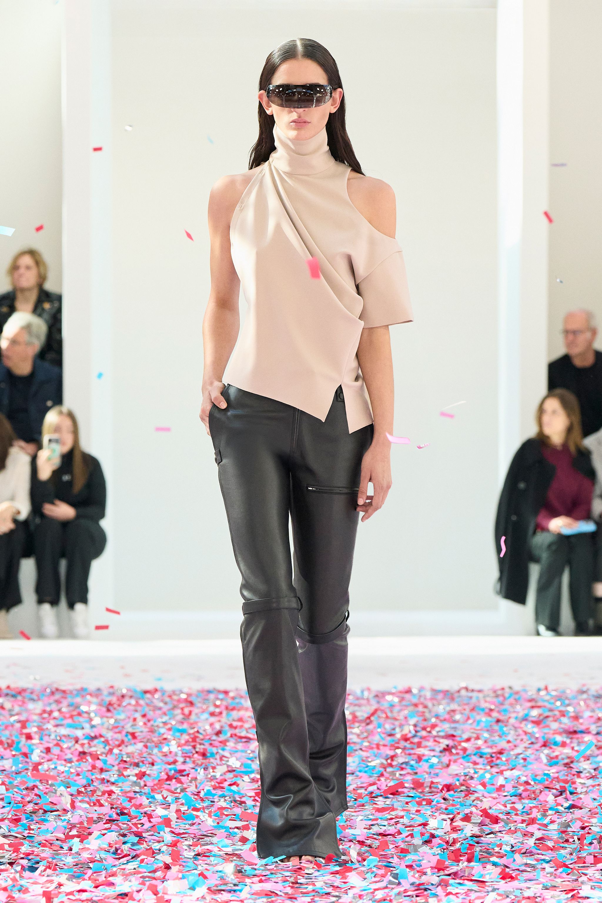 Elegant black cropped jacket and skirt from Courrèges with a modern fashion runway design.