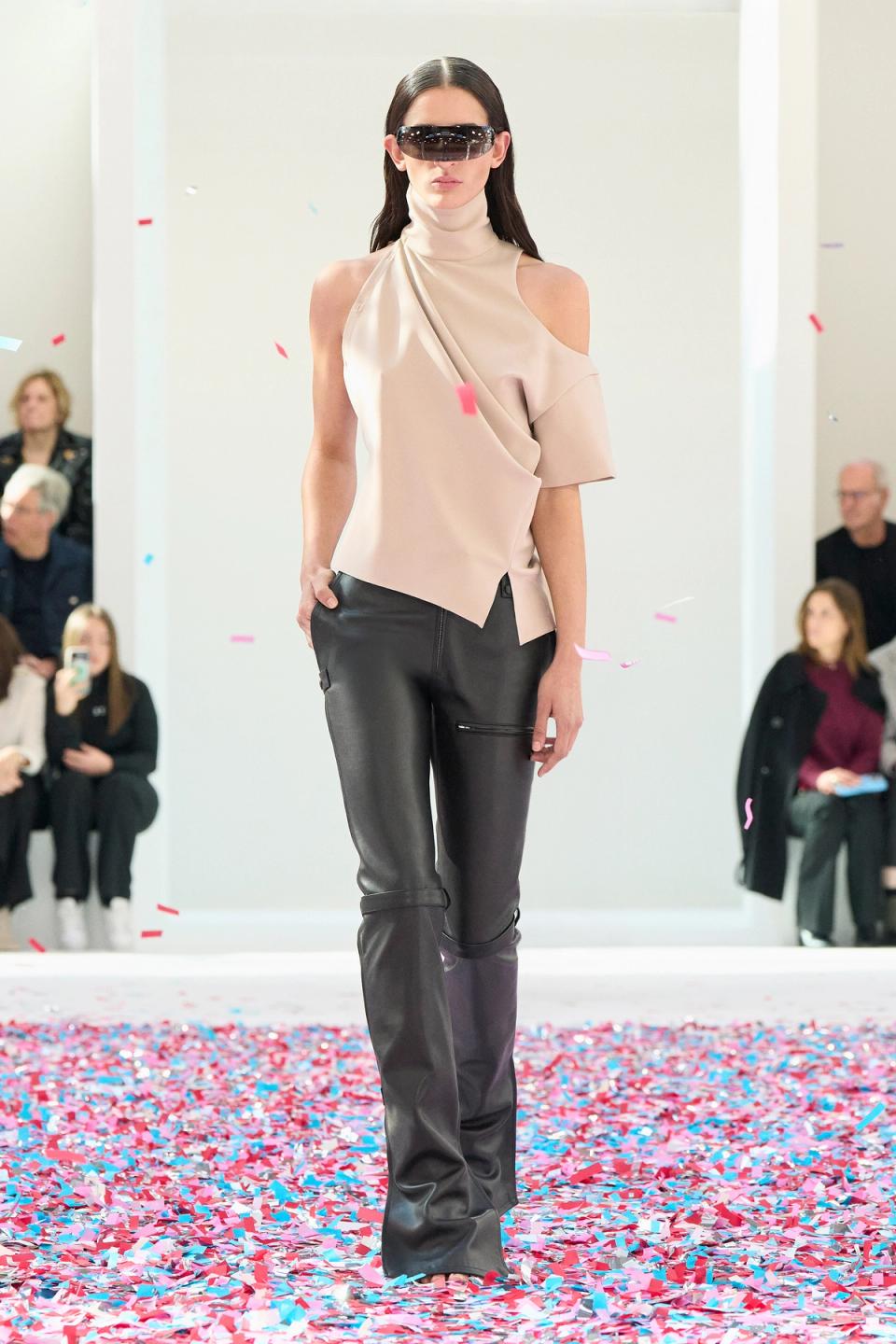 Elegant black cropped jacket and skirt from Courrèges with a modern fashion runway design.
