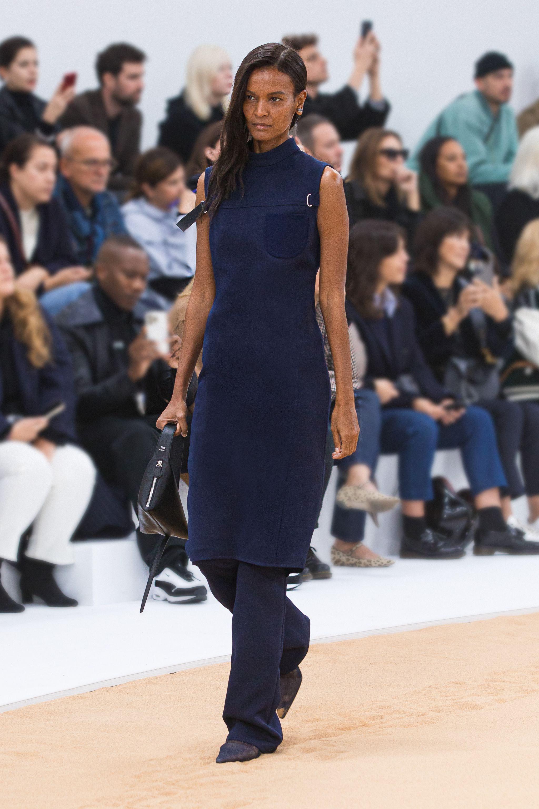 Elegant navy dress by Courrèges showcased on a runway, perfect for a chic fashion statement.