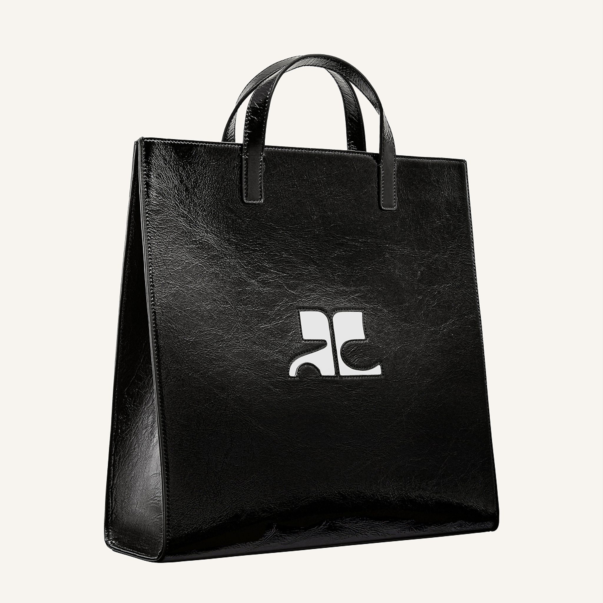Elegant black leather tote bag with cutout logo, perfect for Courrèges fashion accessories.