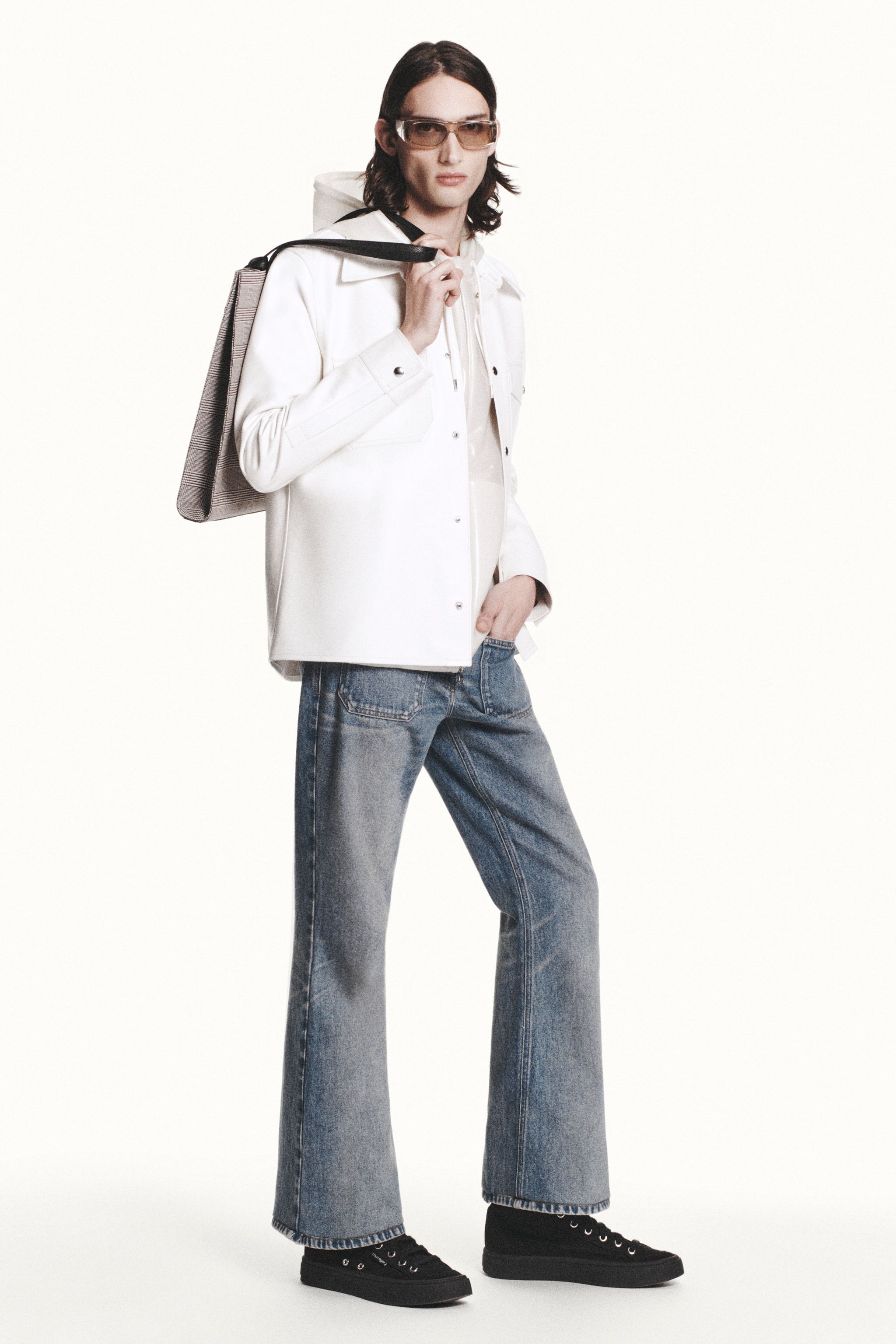 Elegant Courrèges female fashion featuring a white jacket, jeans, and accessories, perfect for e-commerce.