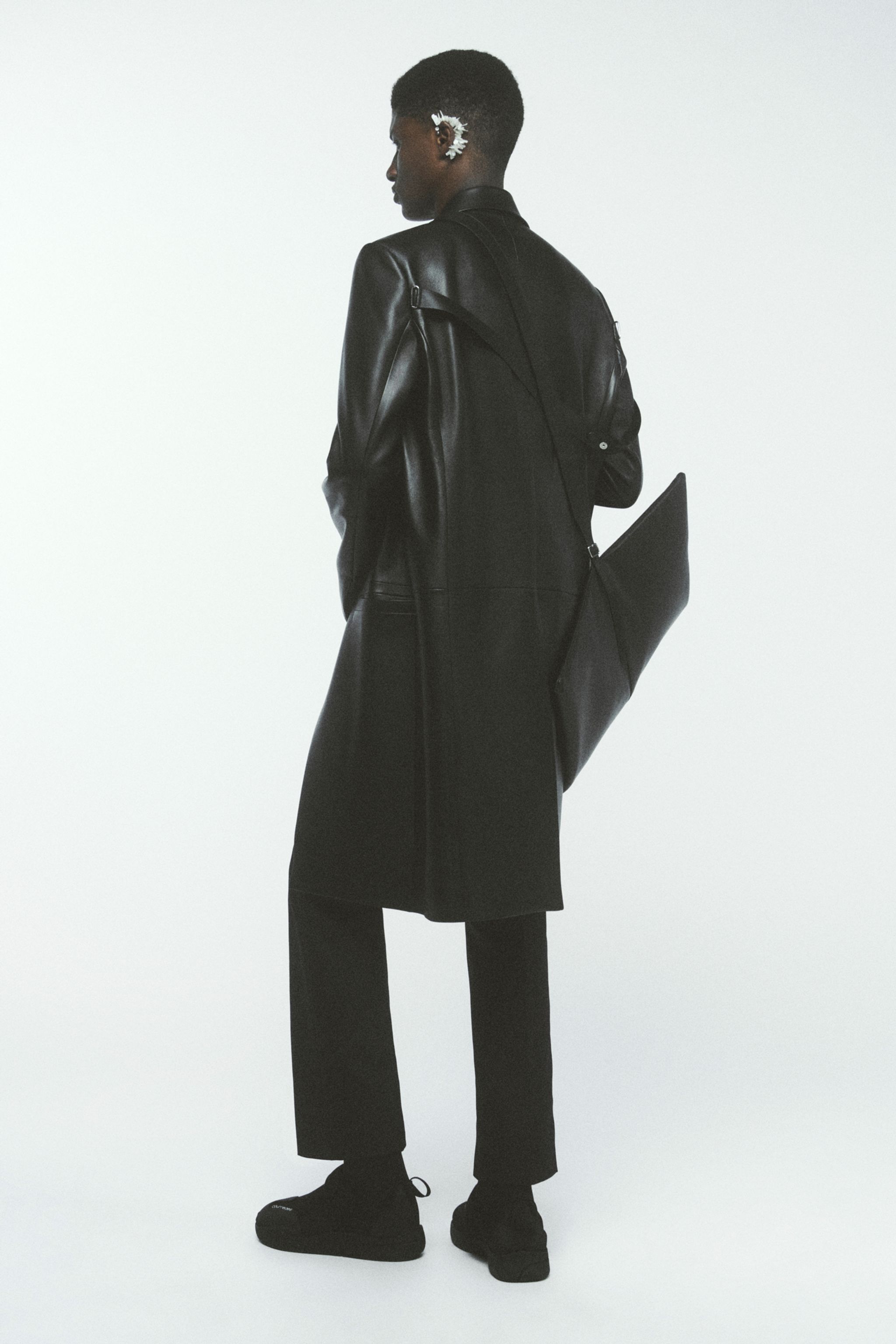 Elegant black leather coat styled for Courrèges, perfect for modern fashion statements.