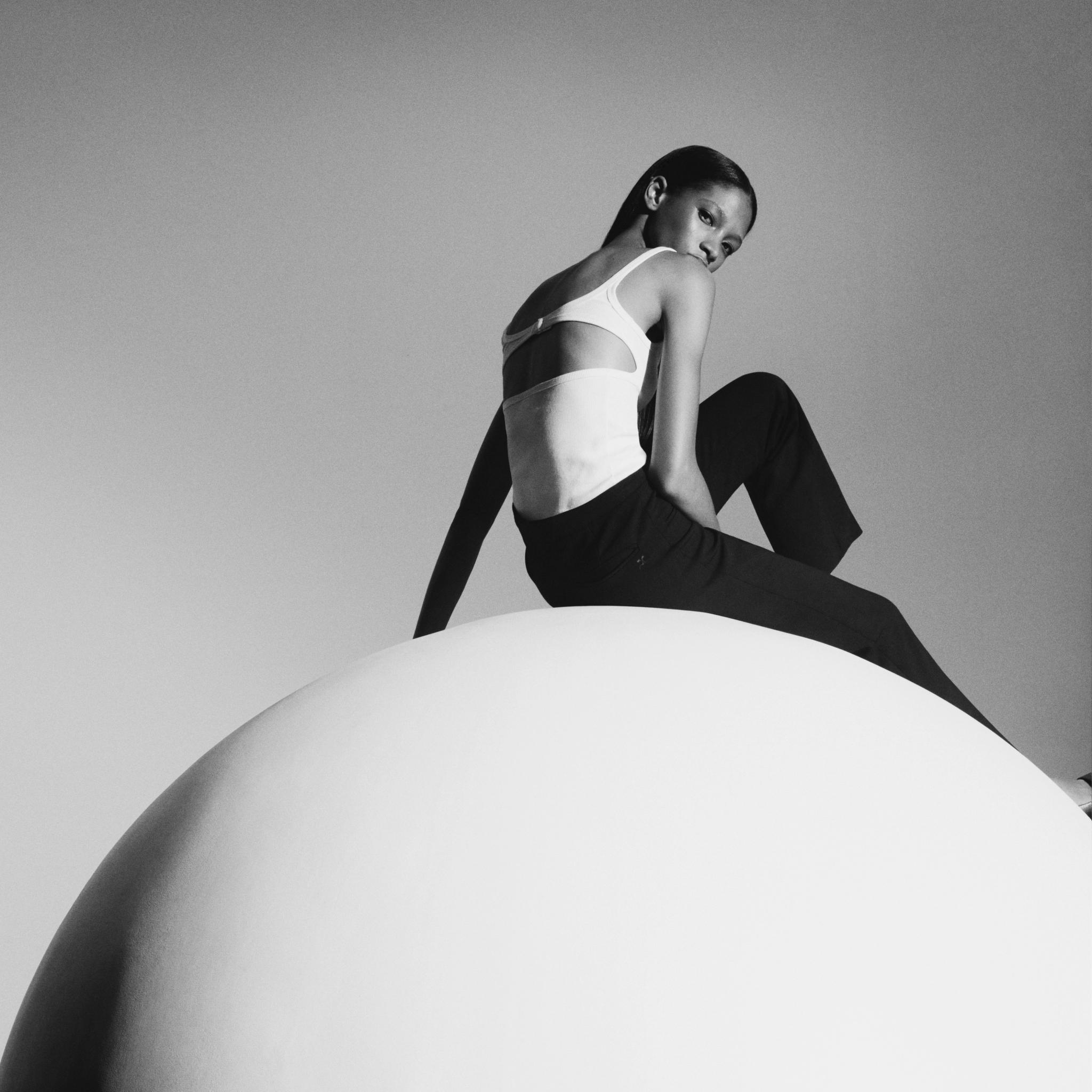 Elegant black and white photo of a female fashion model in Courrèges attire, poised and stylish.