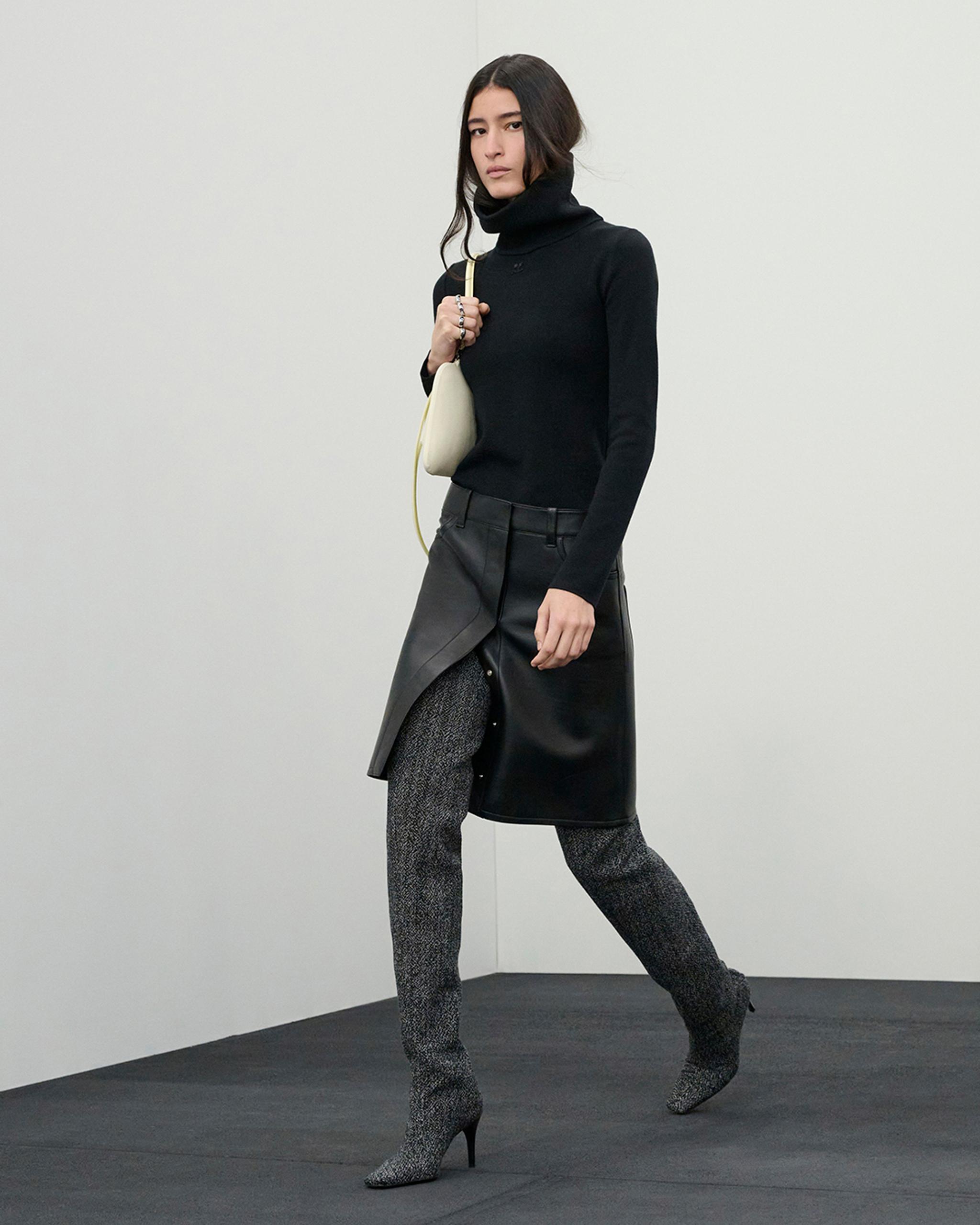 Elegant black turtleneck sweater paired with embossed leather skirt and patterned high heels, Courrèges fashion.